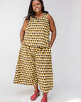 Model wearing mustard and black triangle print pants and tank.