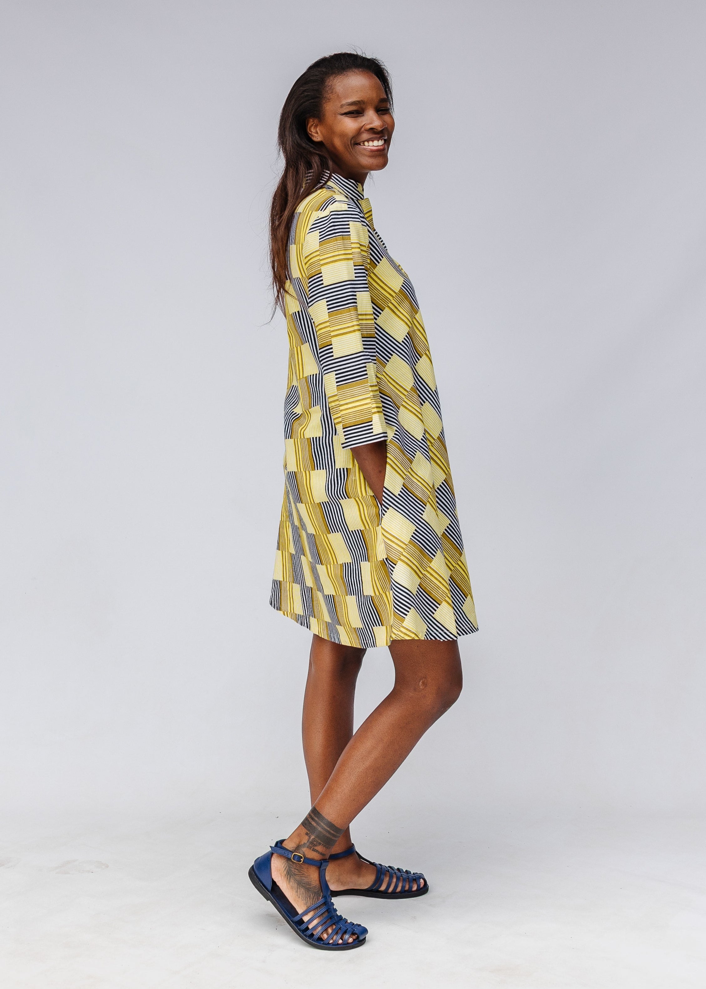 Model wearing yellow and black striped dress.