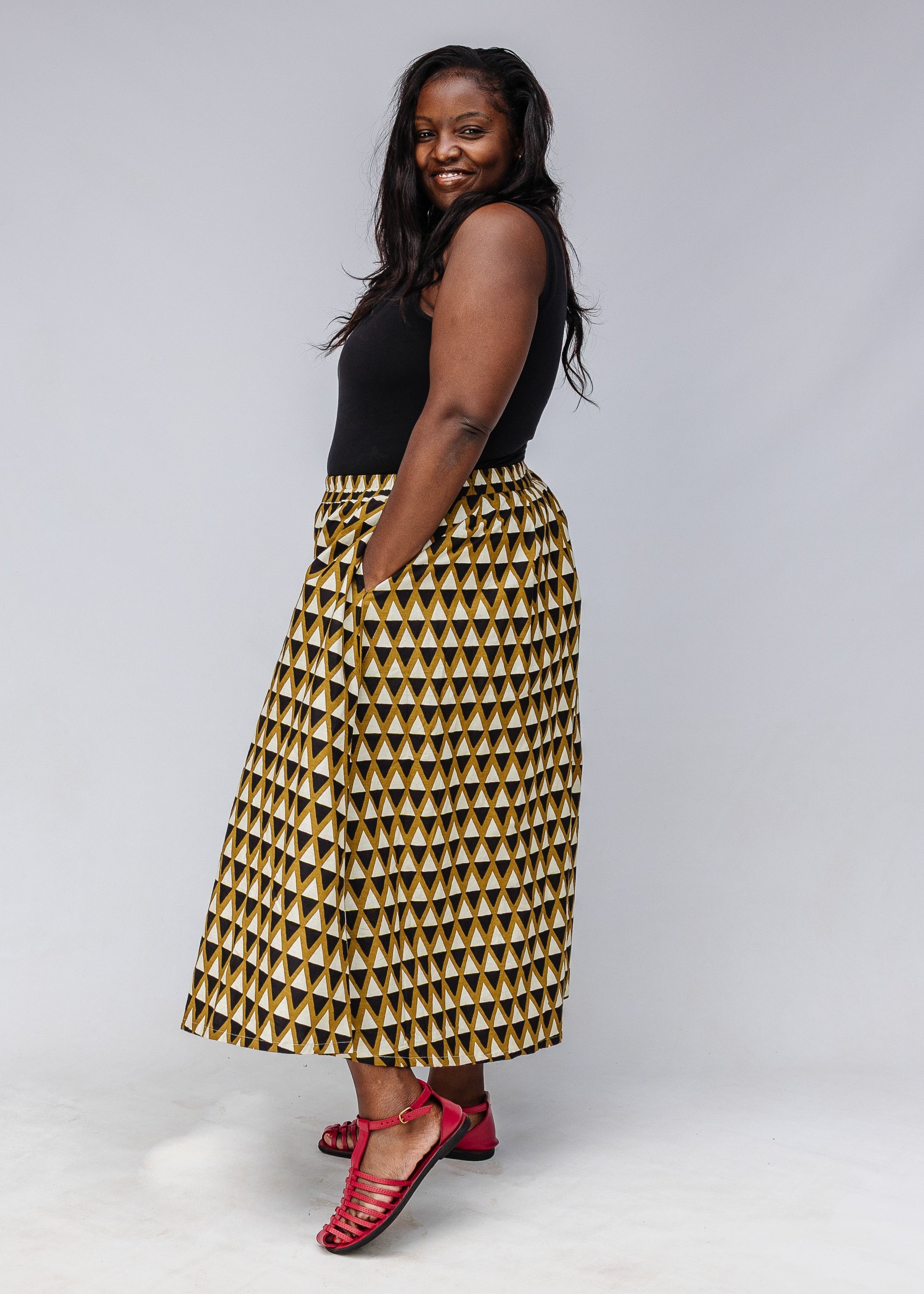 Model wearing mustard and black triangle print pants.