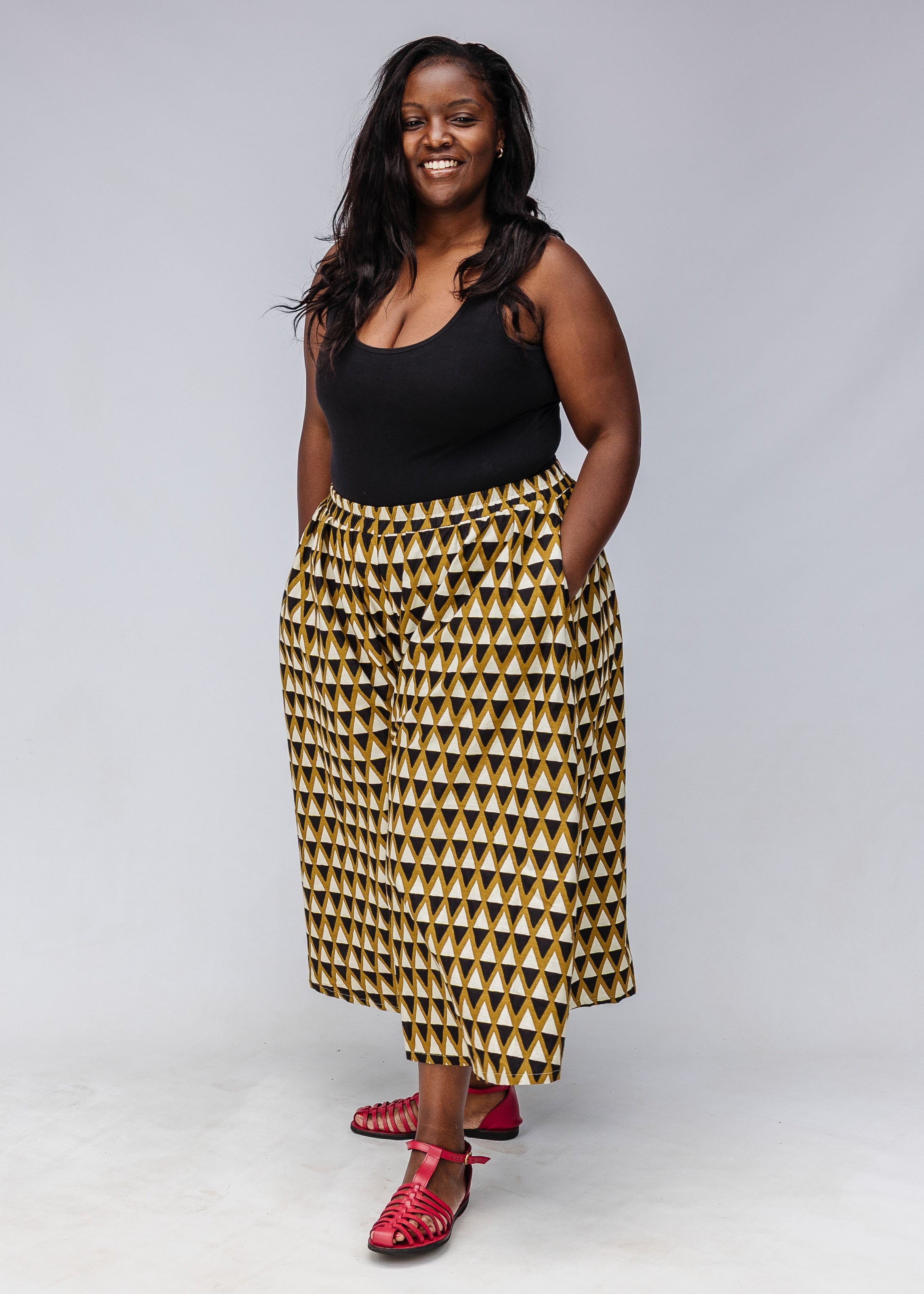 Model wearing mustard and black triangle print pants.