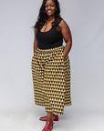 Model wearing mustard and black triangle print pants.