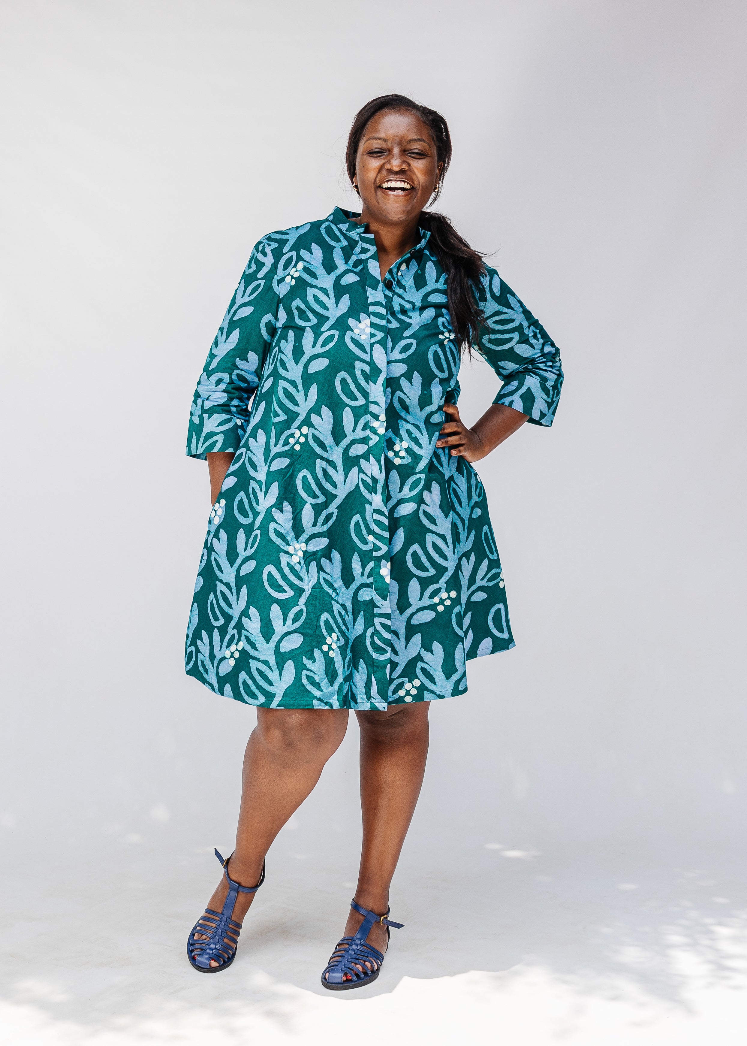Model wearing green and blue floral batik dress. 