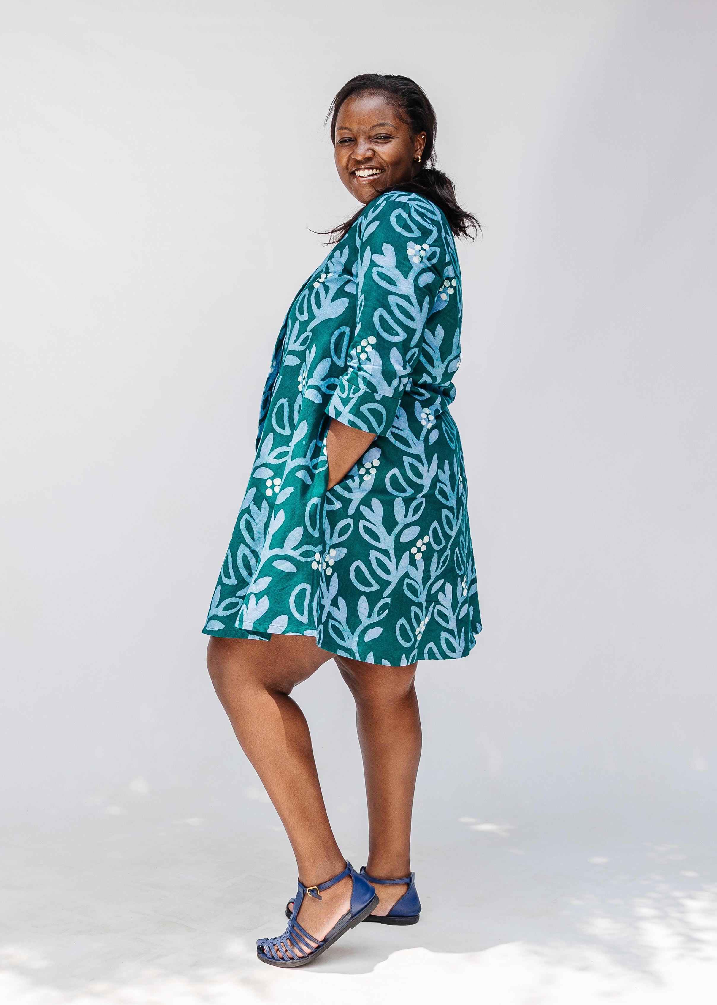 Model wearing green and blue floral batik dress. 