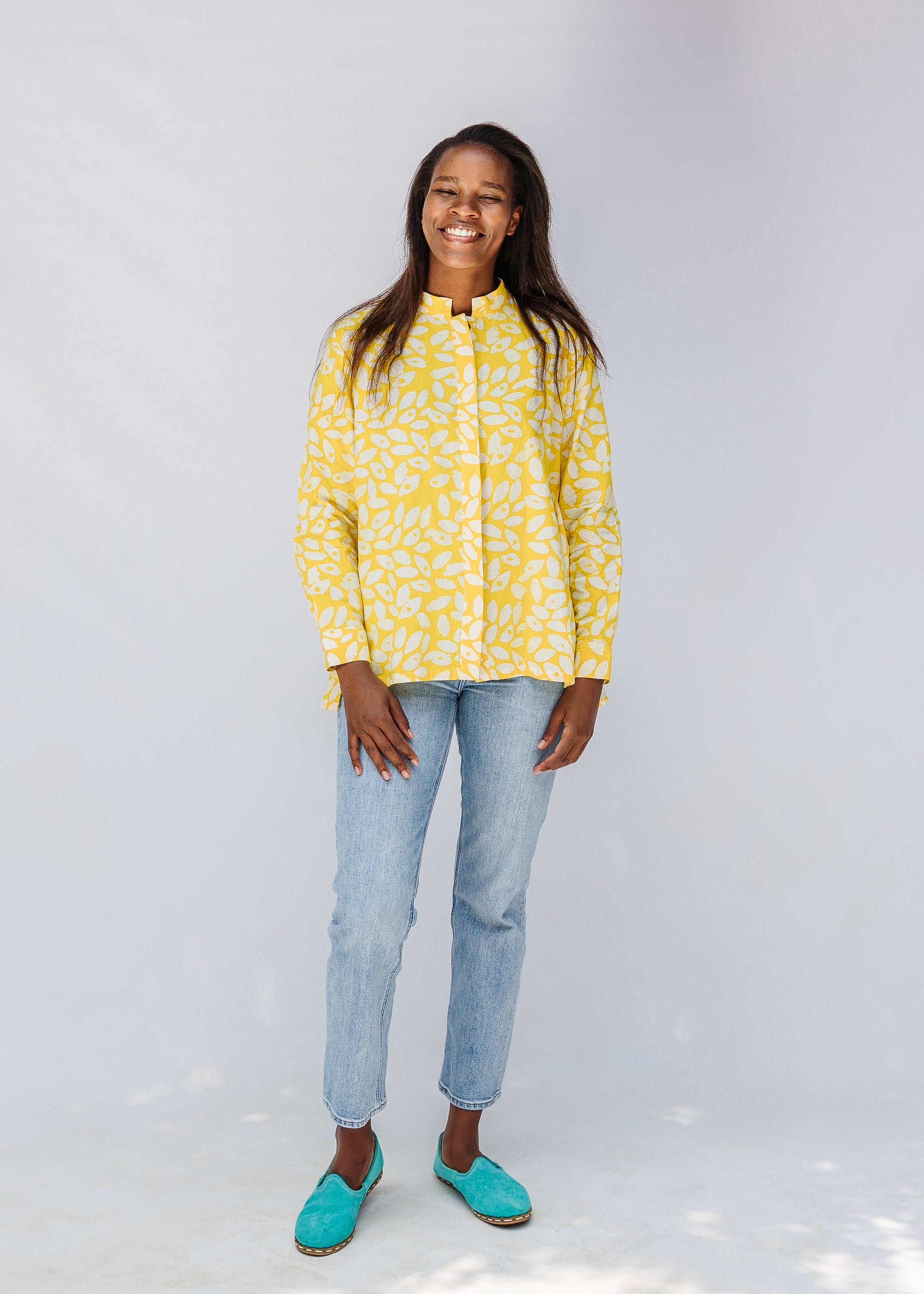 Model wearing yellow long sleeve shirt with white leaf print.