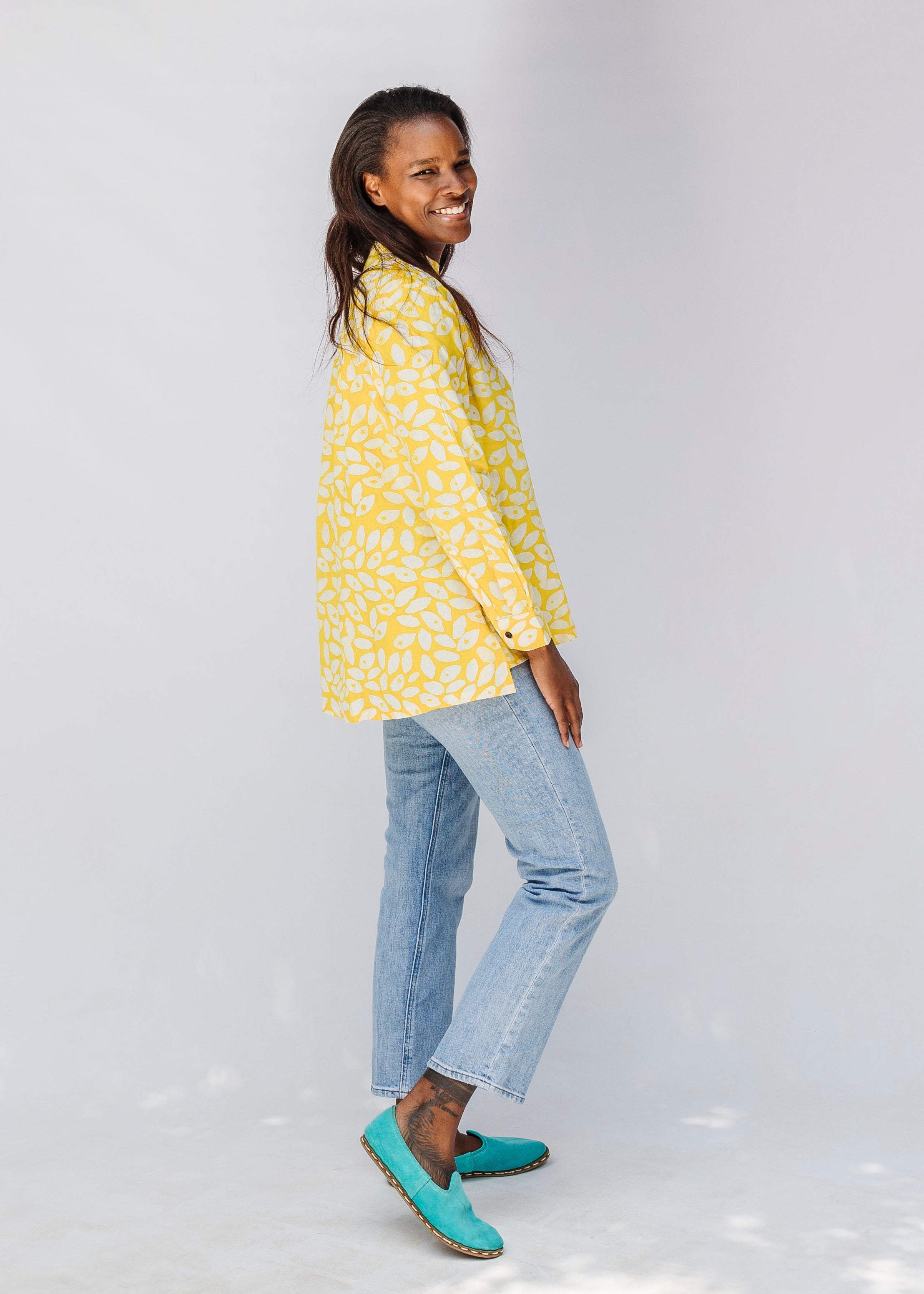 Model wearing yellow long sleeve shirt with white leaf print.