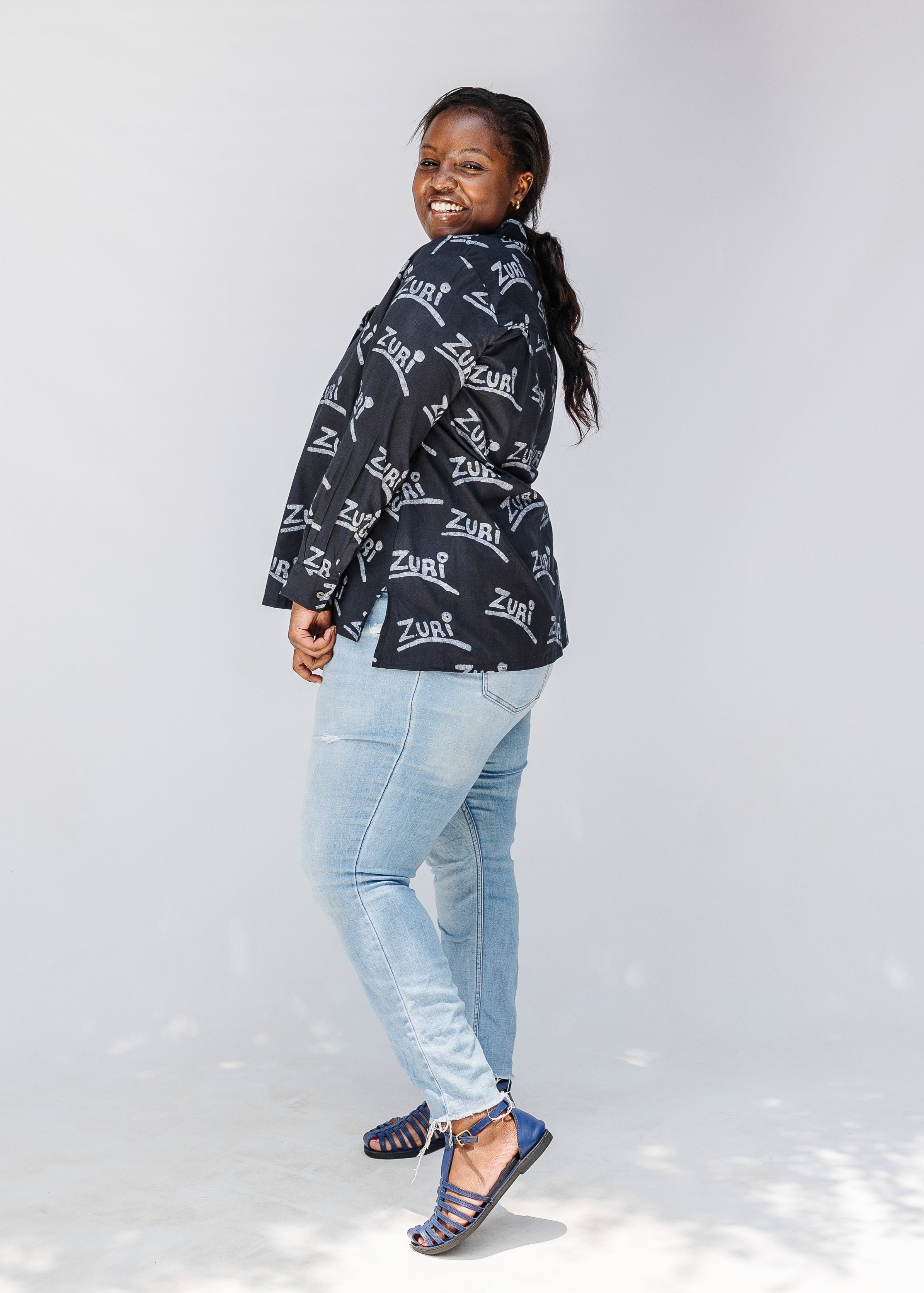 Model wearing black and white long sleeve shirt with Zuri graphic print.