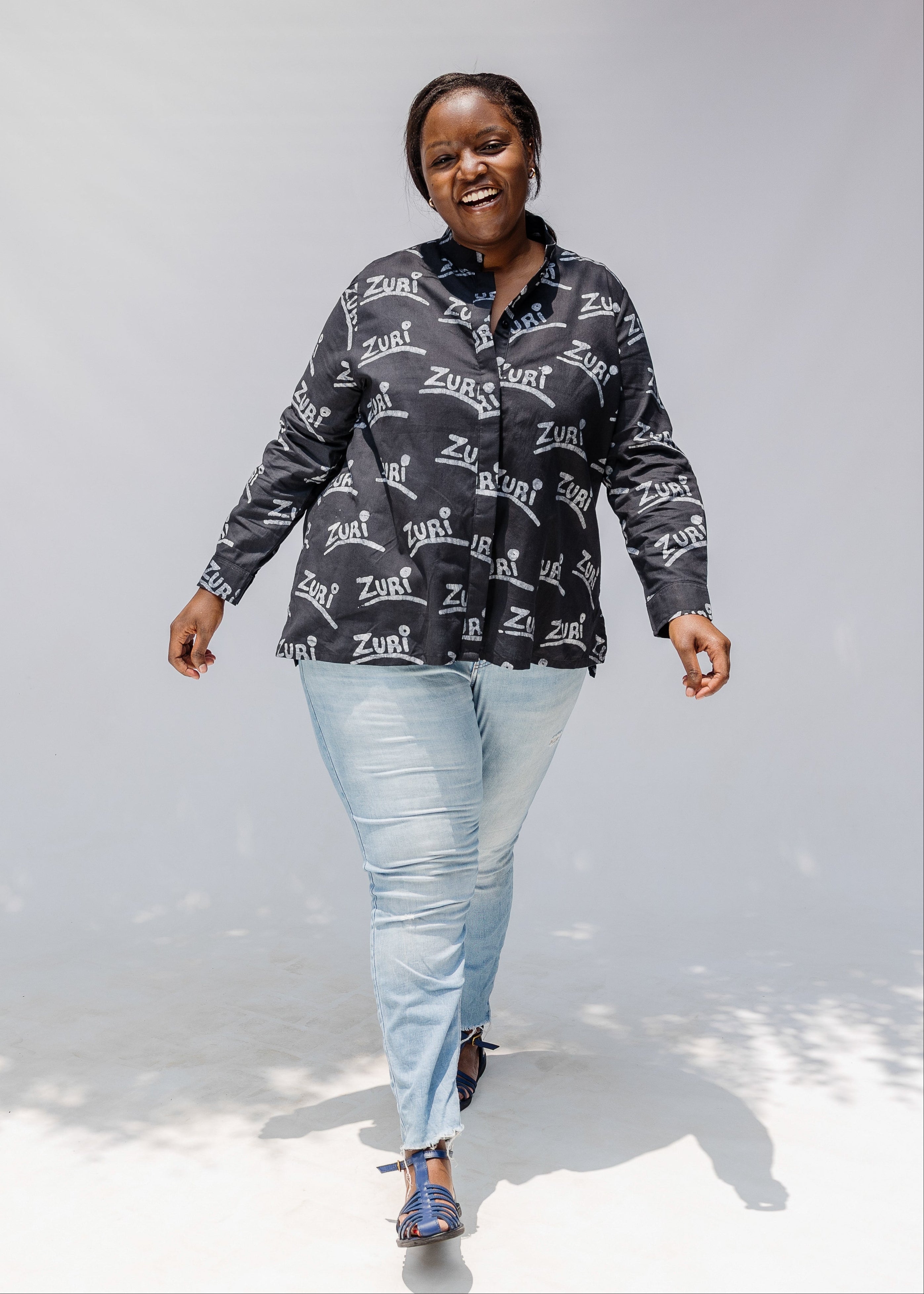 Model wearing black and white long sleeve shirt with Zuri graphic print.