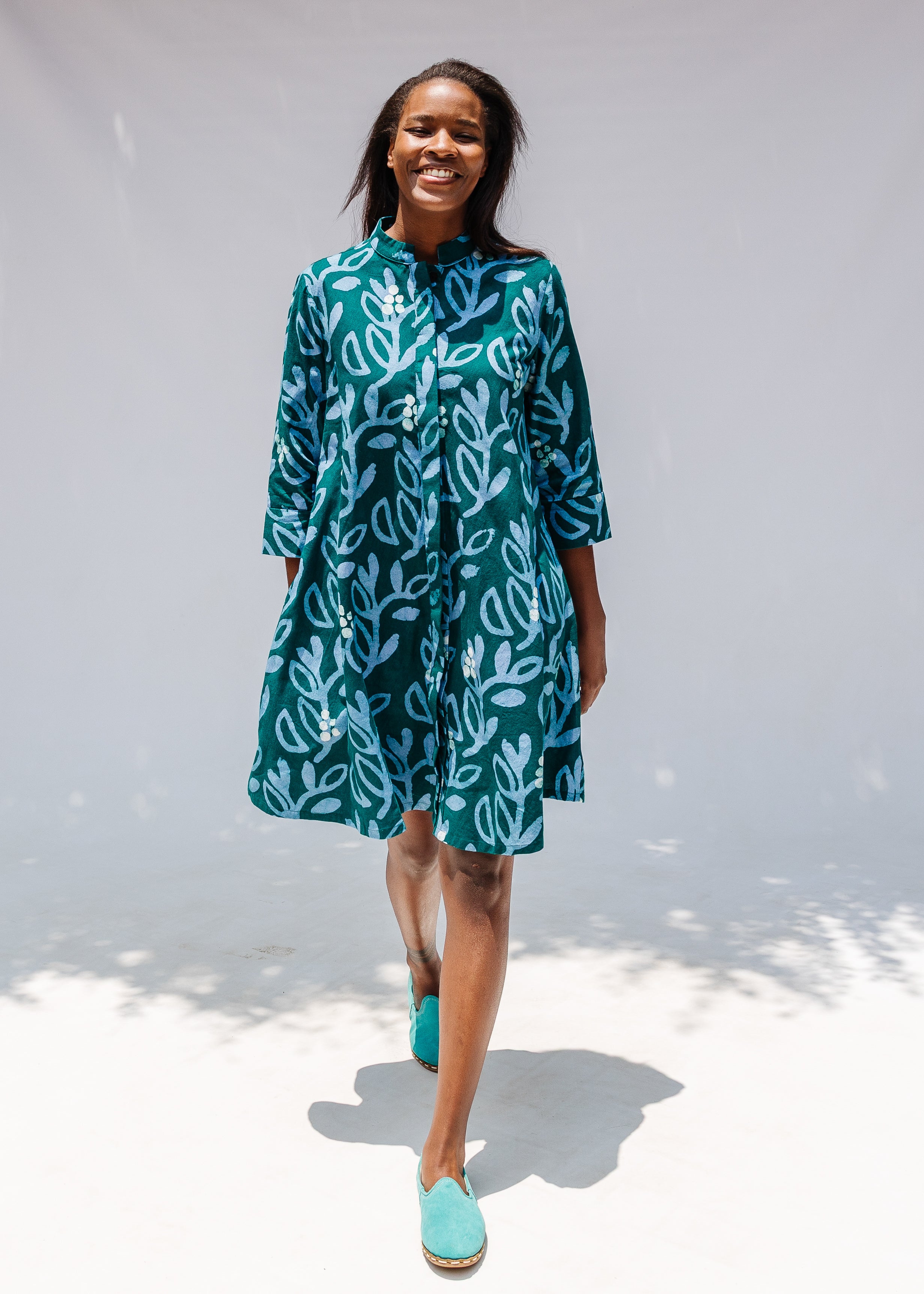 Model wearing green and blue floral batik dress. 