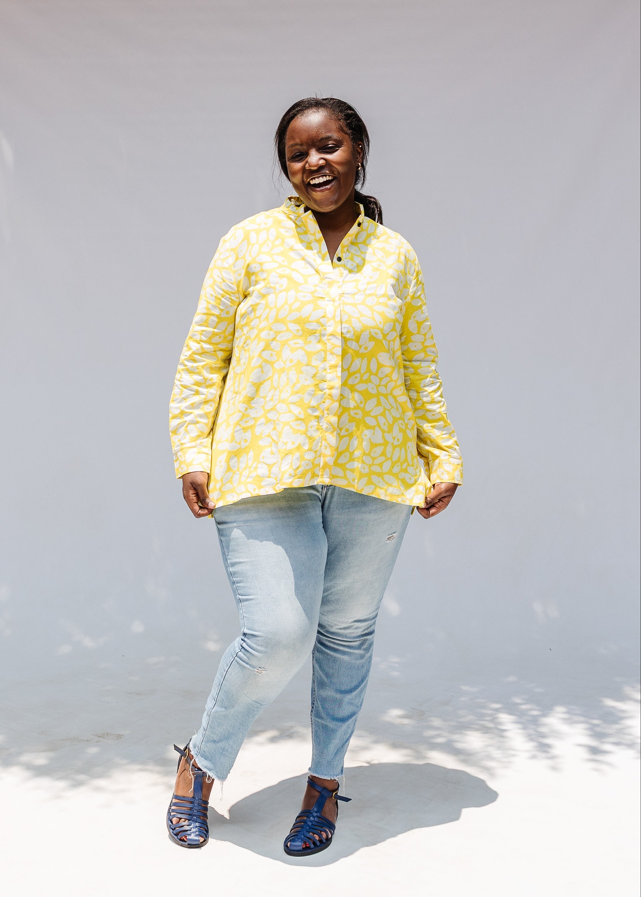 Model wearing yellow long sleeve shirt with white leaf print.