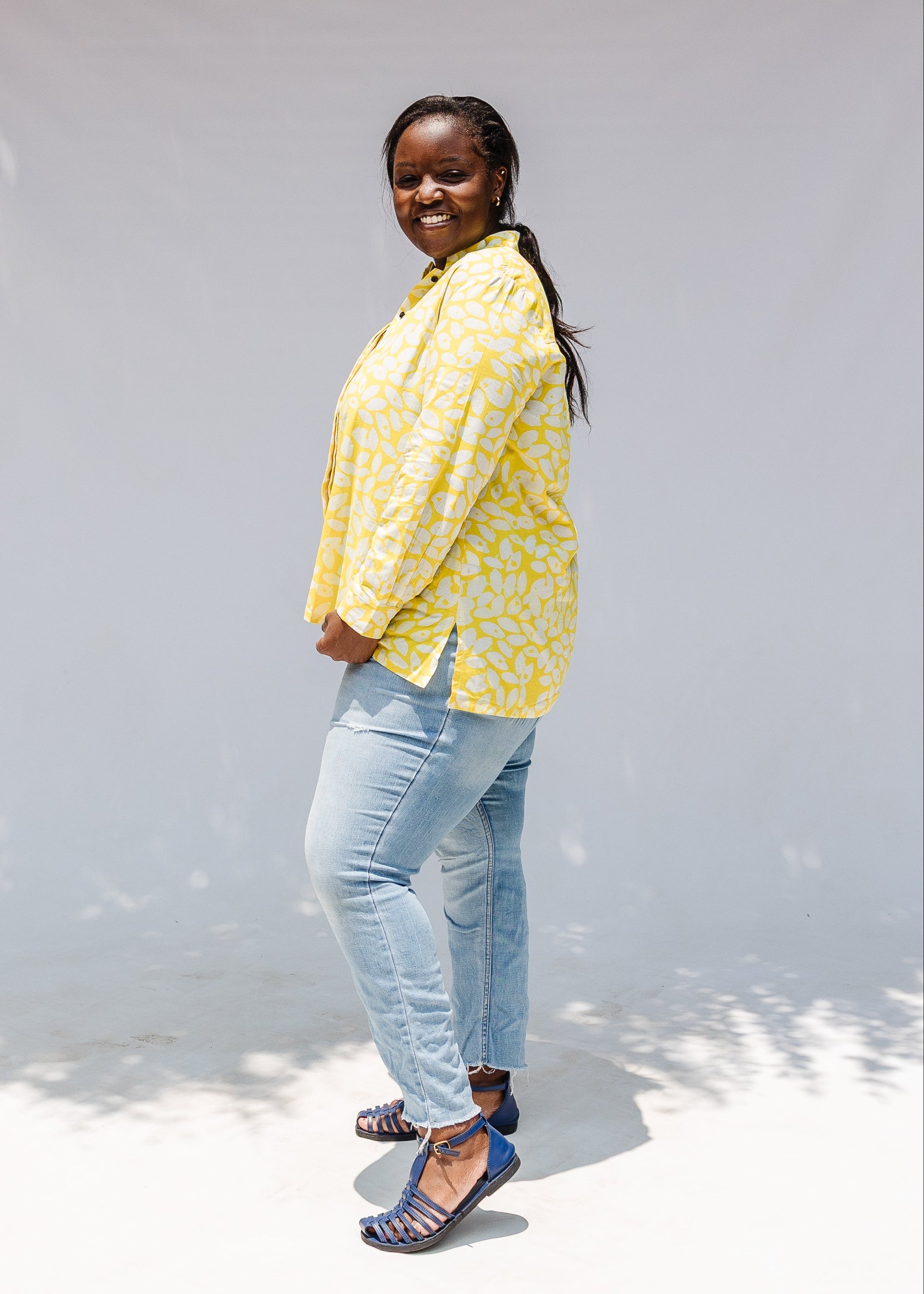 Model wearing yellow long sleeve shirt with white leaf print.