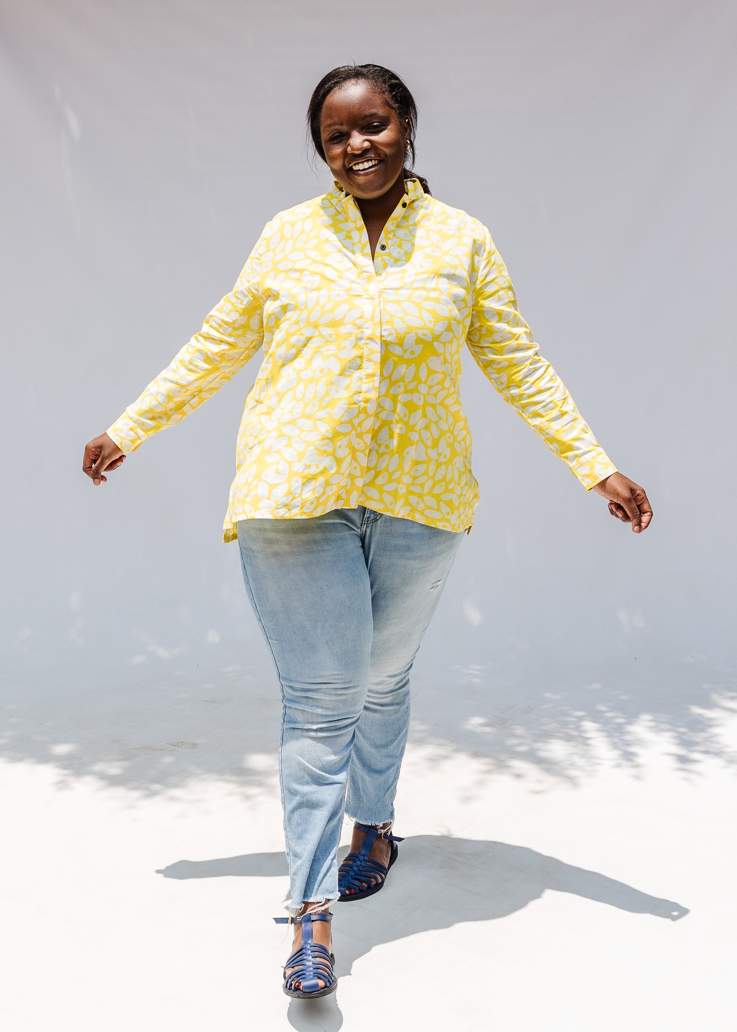 Model wearing yellow long sleeve shirt with white leaf print.