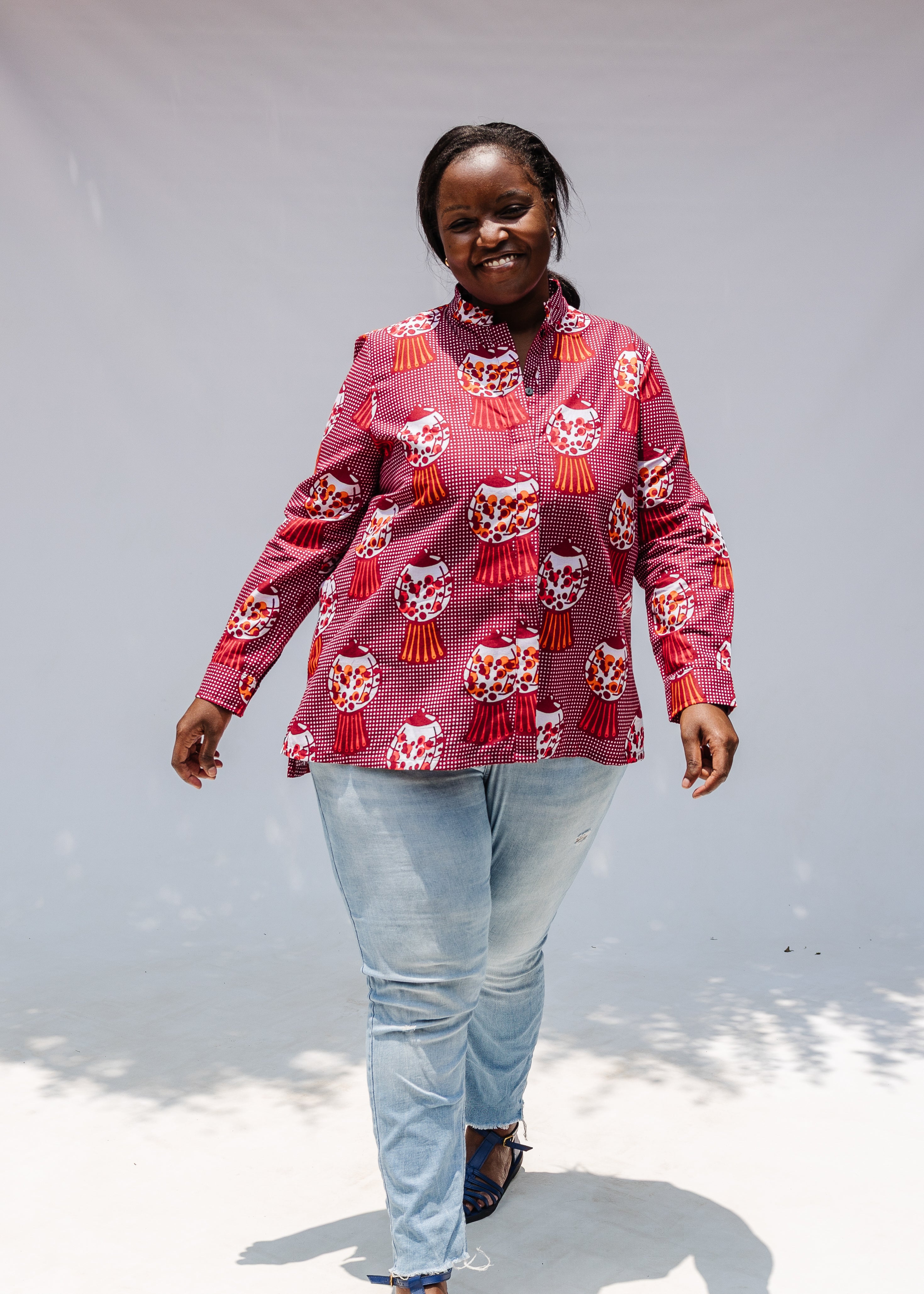 Model wearing red shirt with orange and white gumball print.