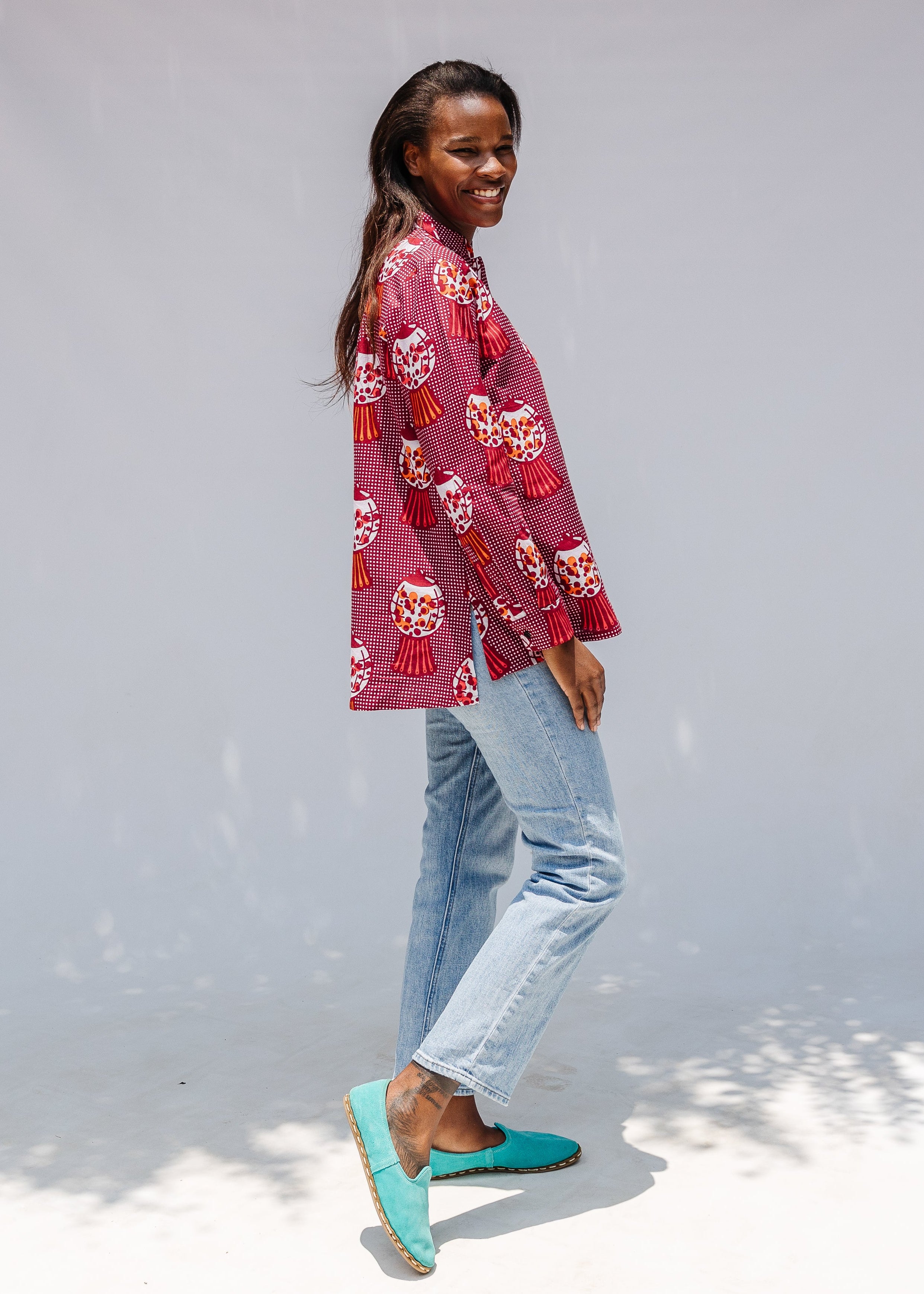 Model wearing red shirt with orange and white gumball print.