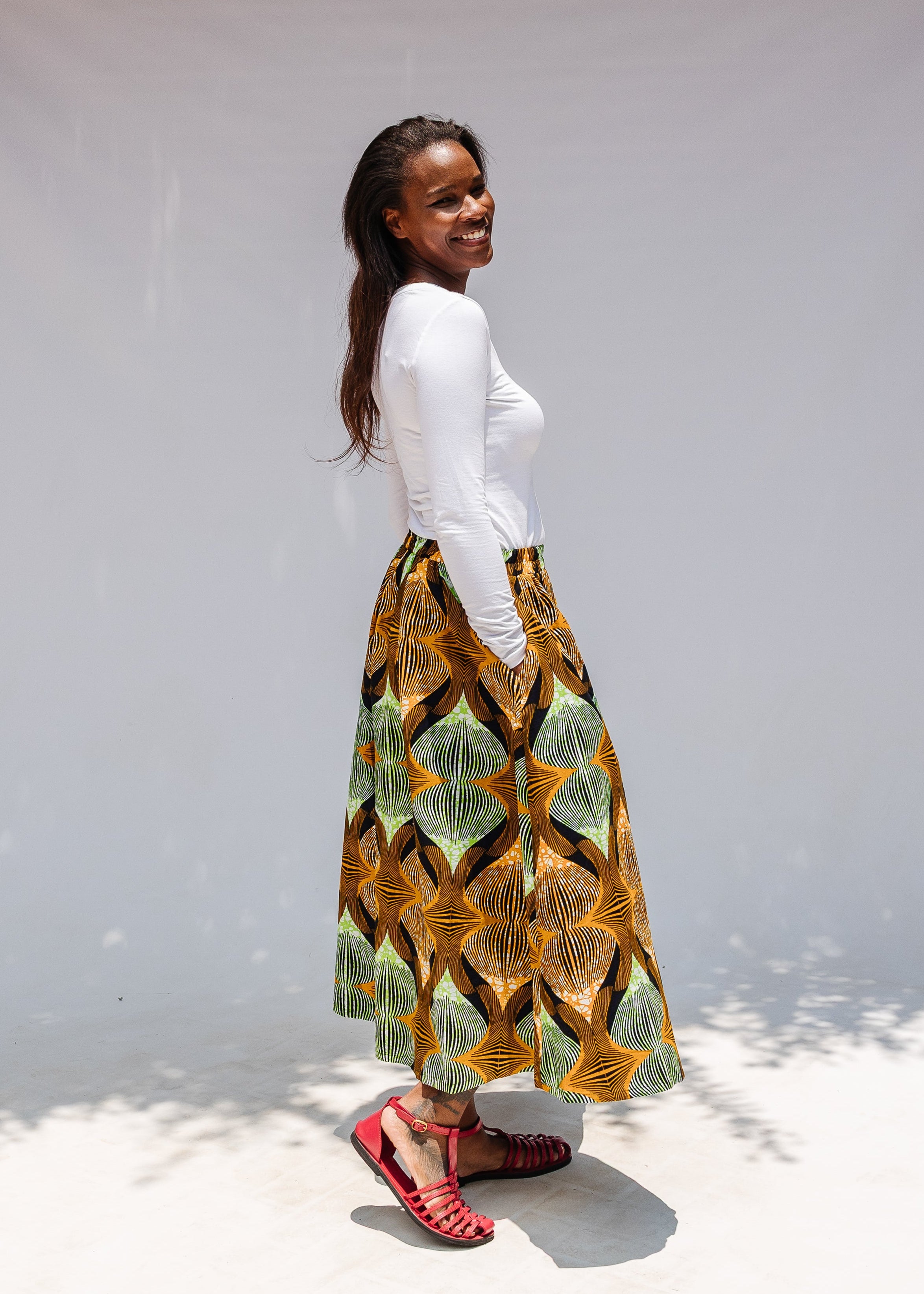 Model wearing orange and green geometric print pants.
