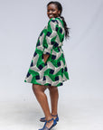 Model wearing green, black and white abstract print dress. 