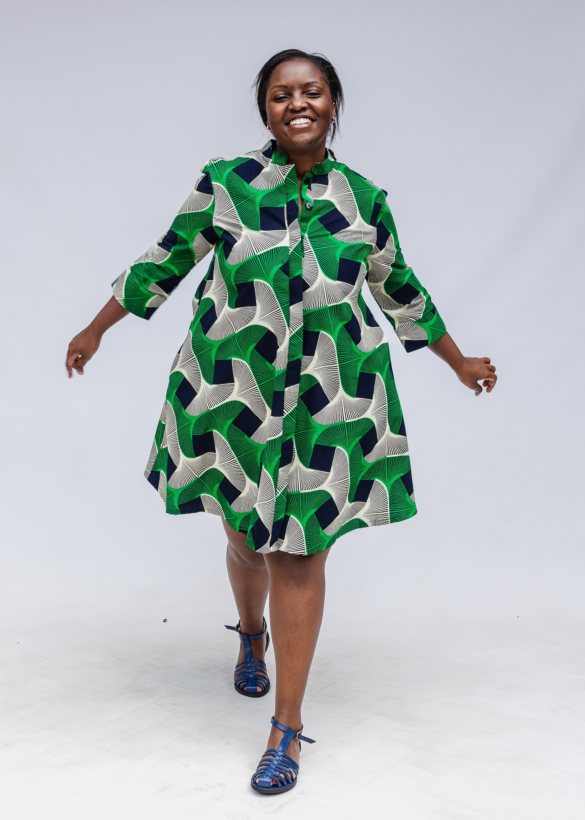 Model wearing green, black and white abstract print dress. 