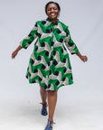 Model wearing green, black and white abstract print dress. 