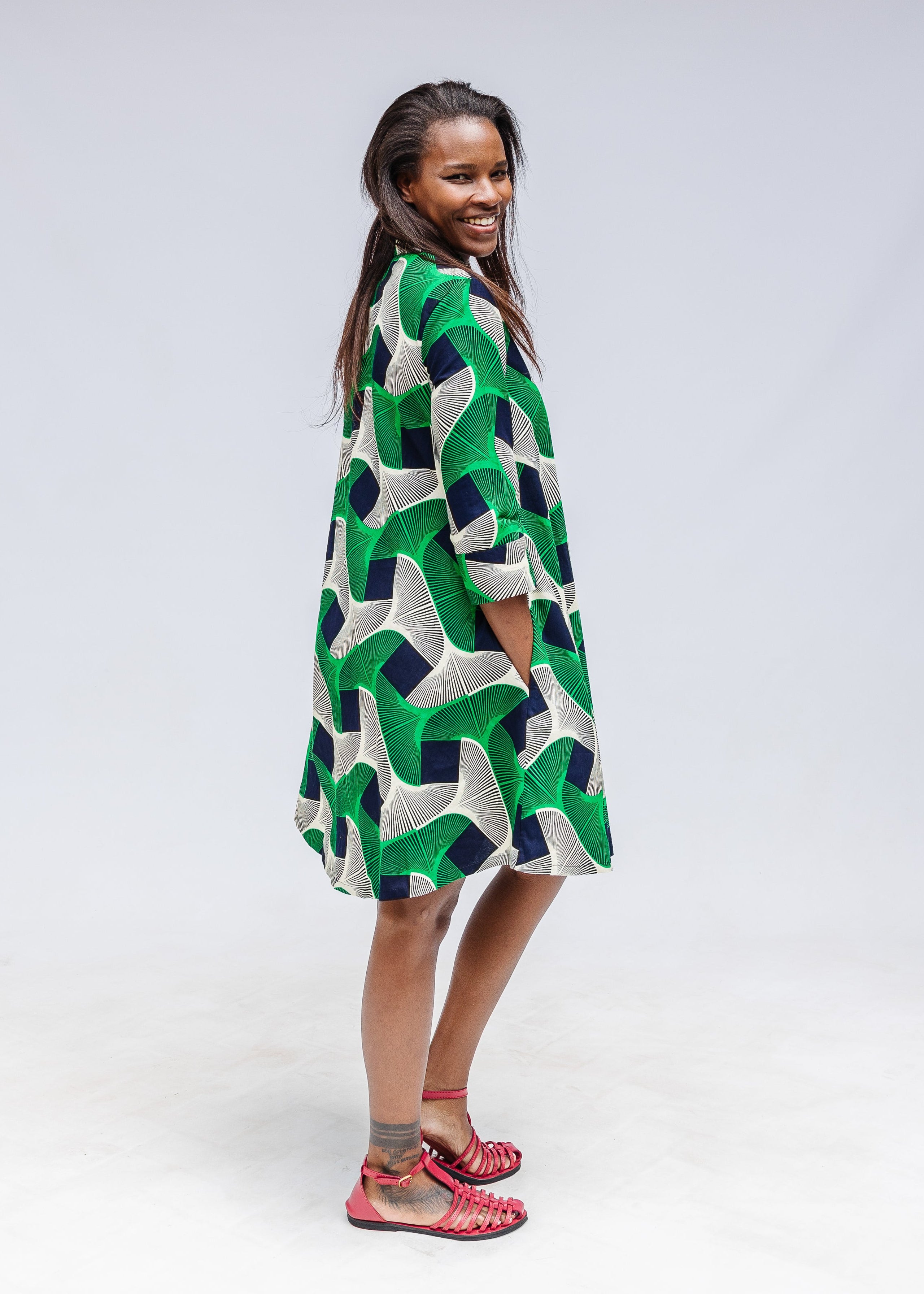 Model wearing green, black and white abstract print dress. 