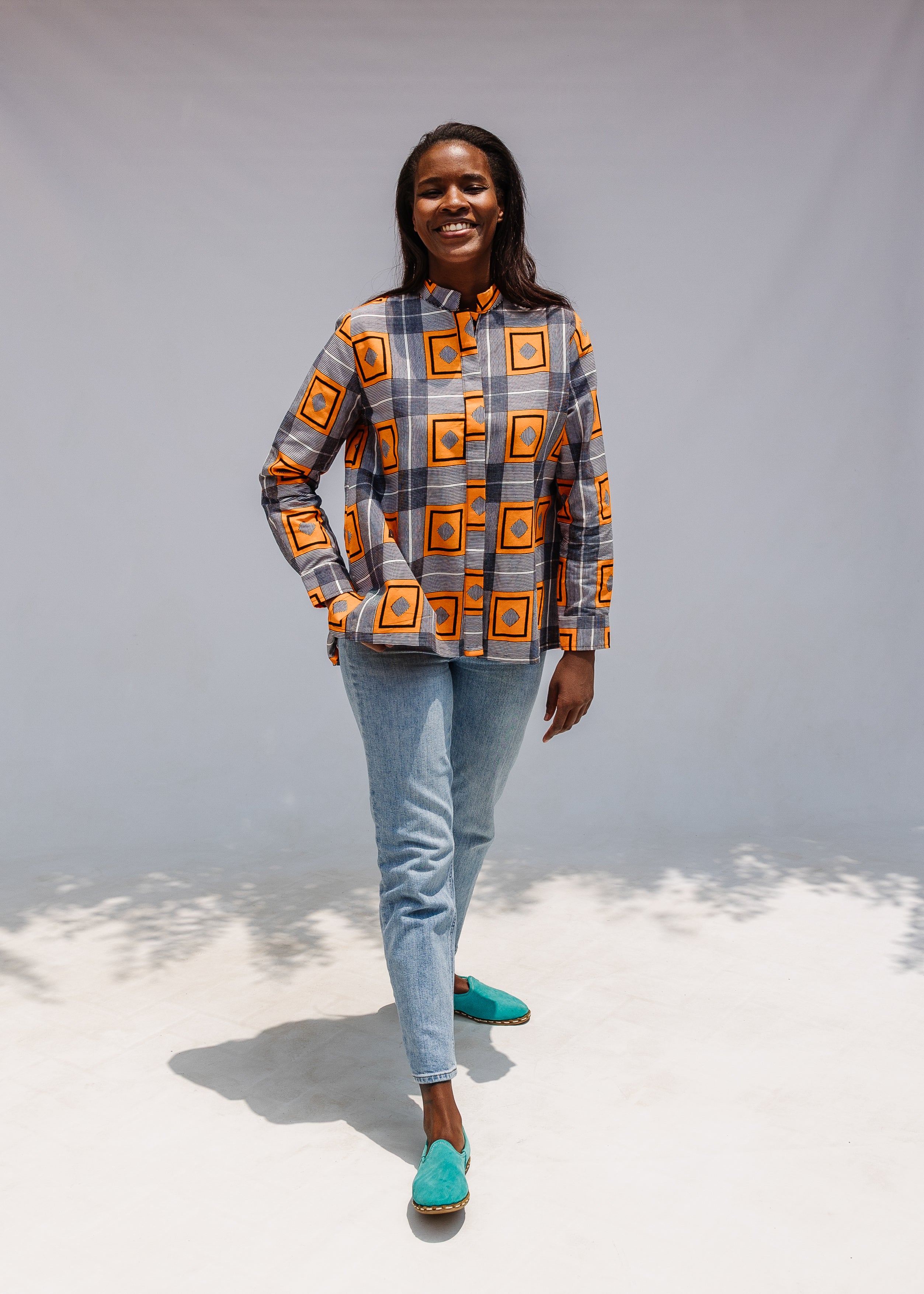 Model wearing orange, navy and white geometric print shirt.
