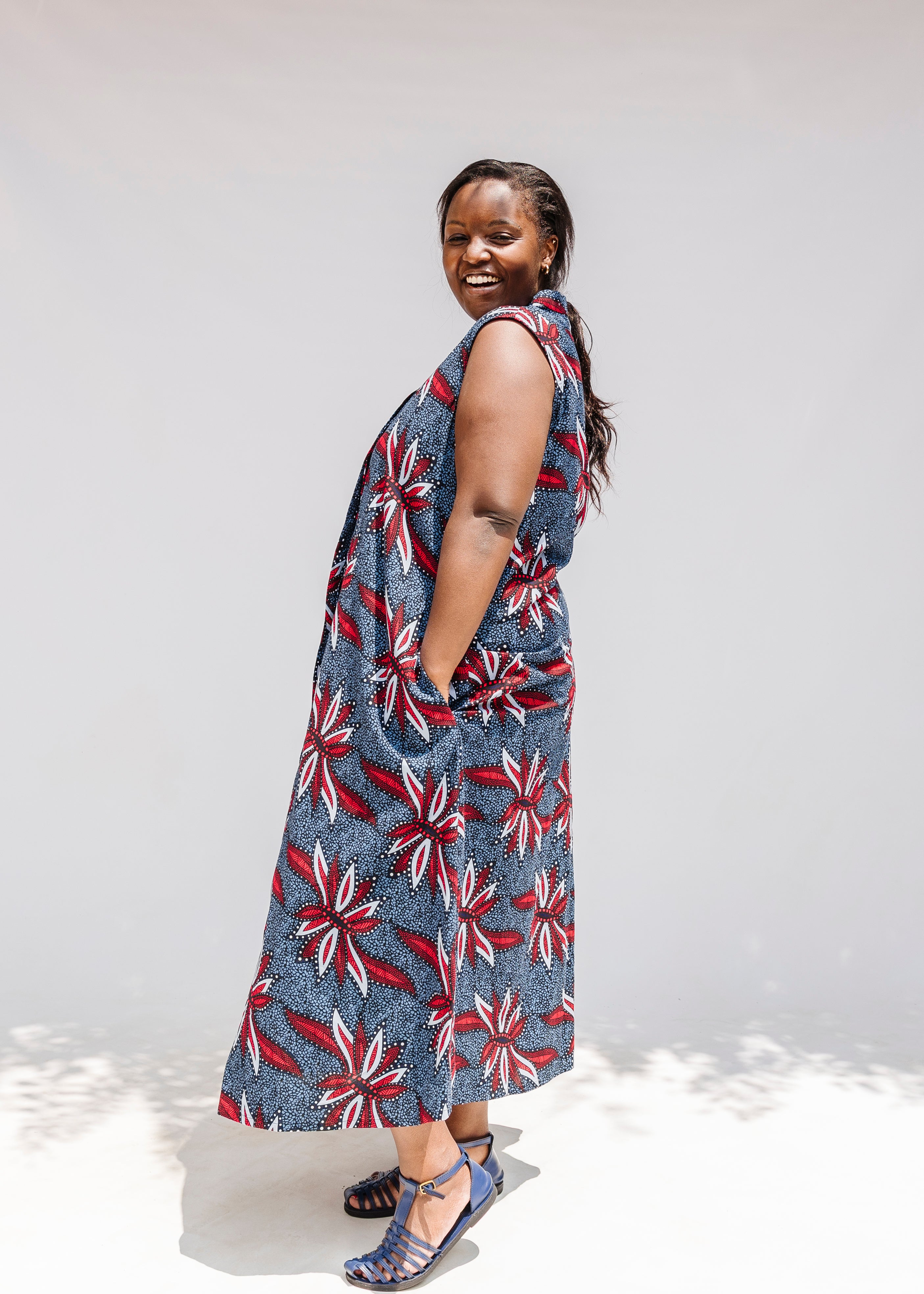 Model wearing grey, red and black dragonfly print dress.