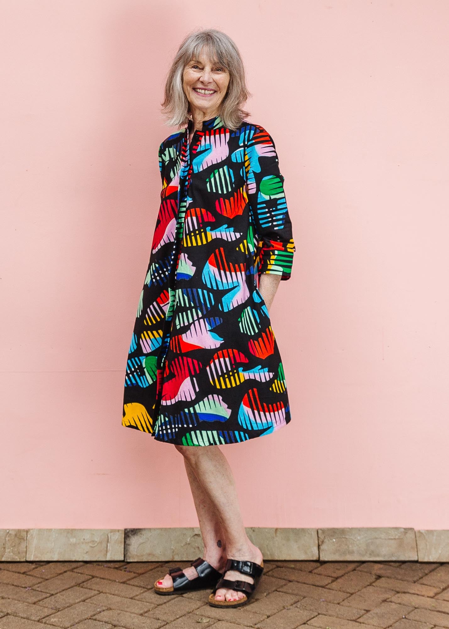 The model is wearing abstract multi-color  figures dress
