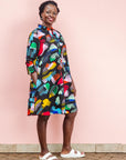 The model is wearing abstract multi-color  figures dress