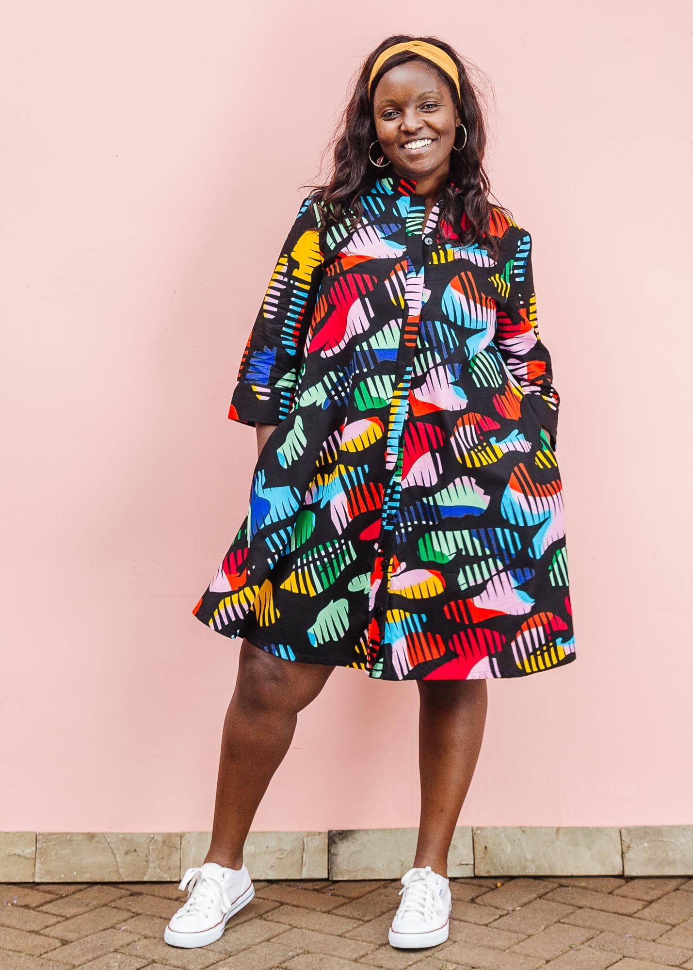 The model is wearing abstract multi-color  figures dress