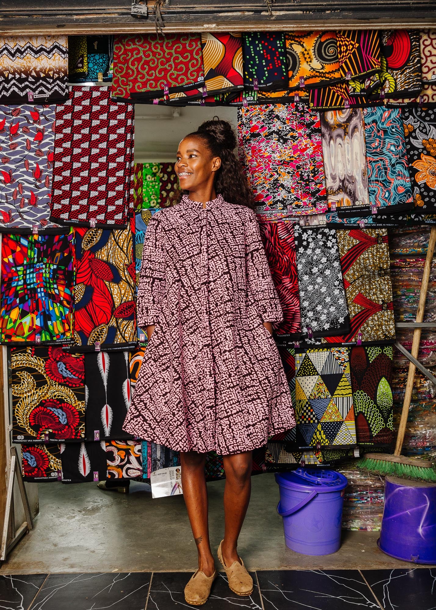 The model is wearing brown and baby pink abstract print dress