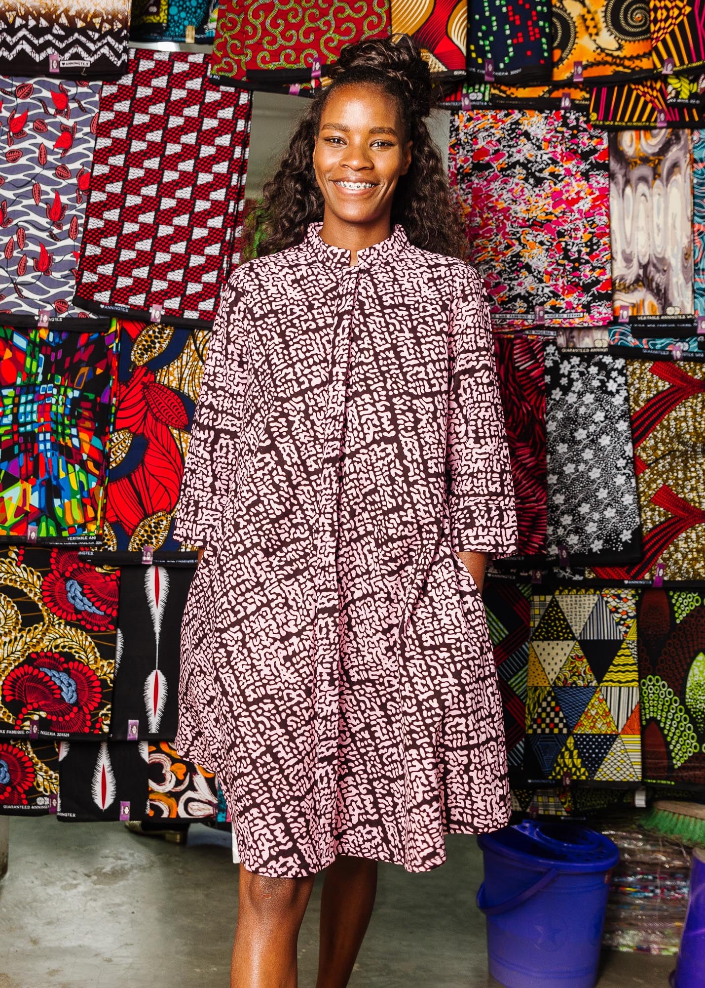 The model is wearing brown and baby pink abstract print dress