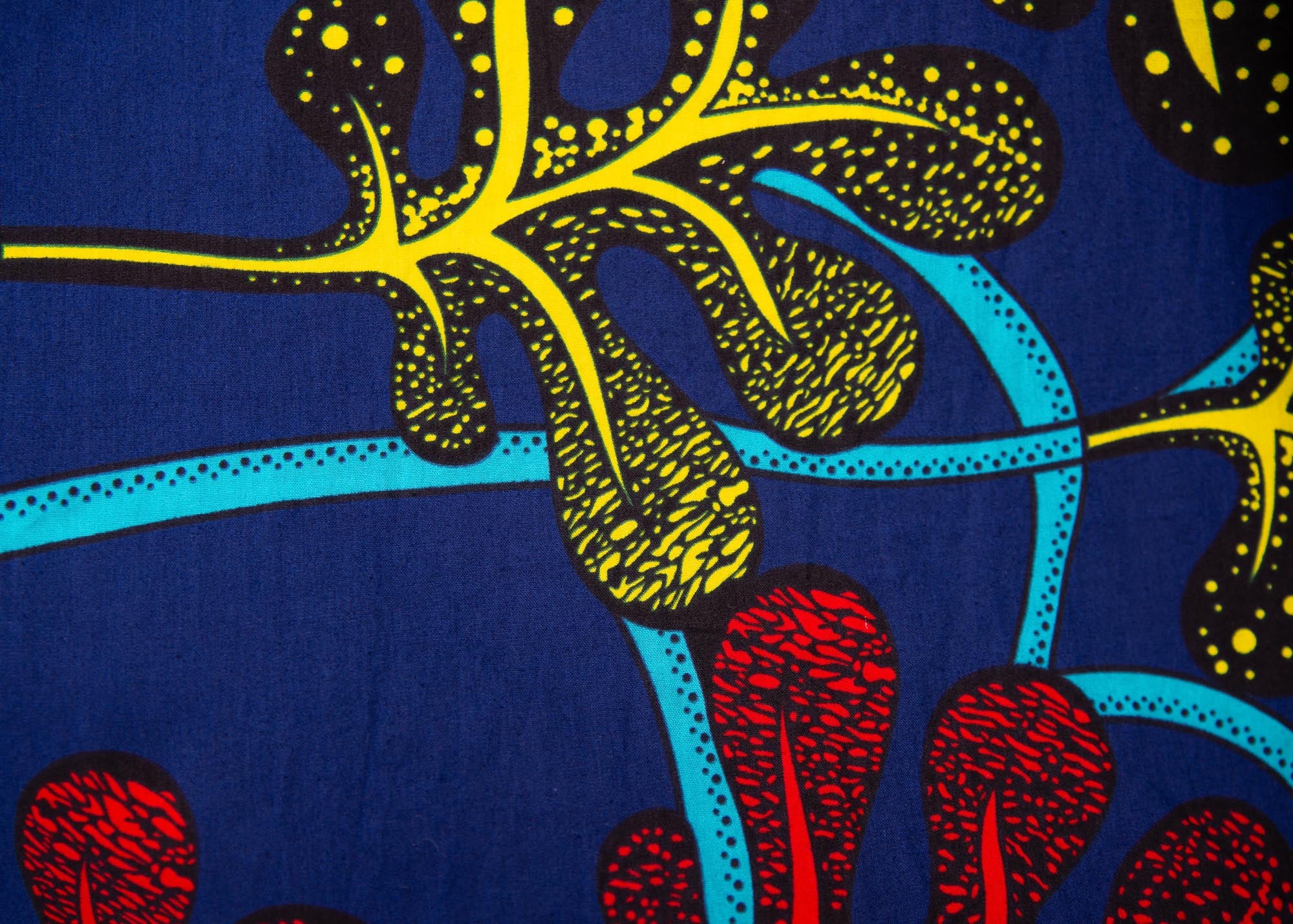 Close up display of blue, red, yellow, black and aqua vine print dress