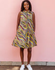 The model is wearing multi-colored abstract print dress