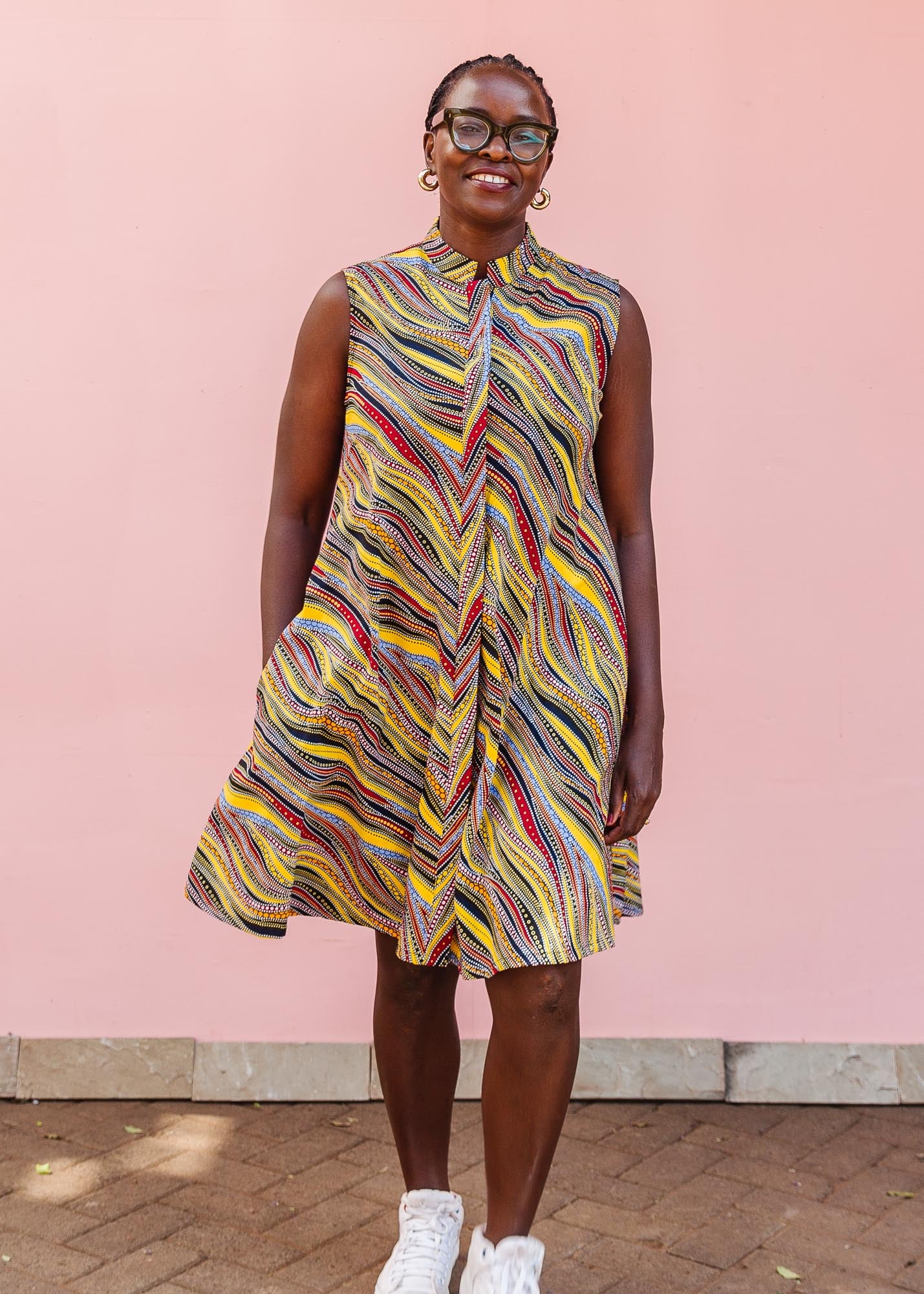 The model is wearing multi-colored abstract print dress
