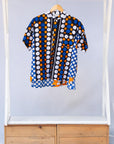 Display of black, white, orange and blue mixed pattern kanga shirt