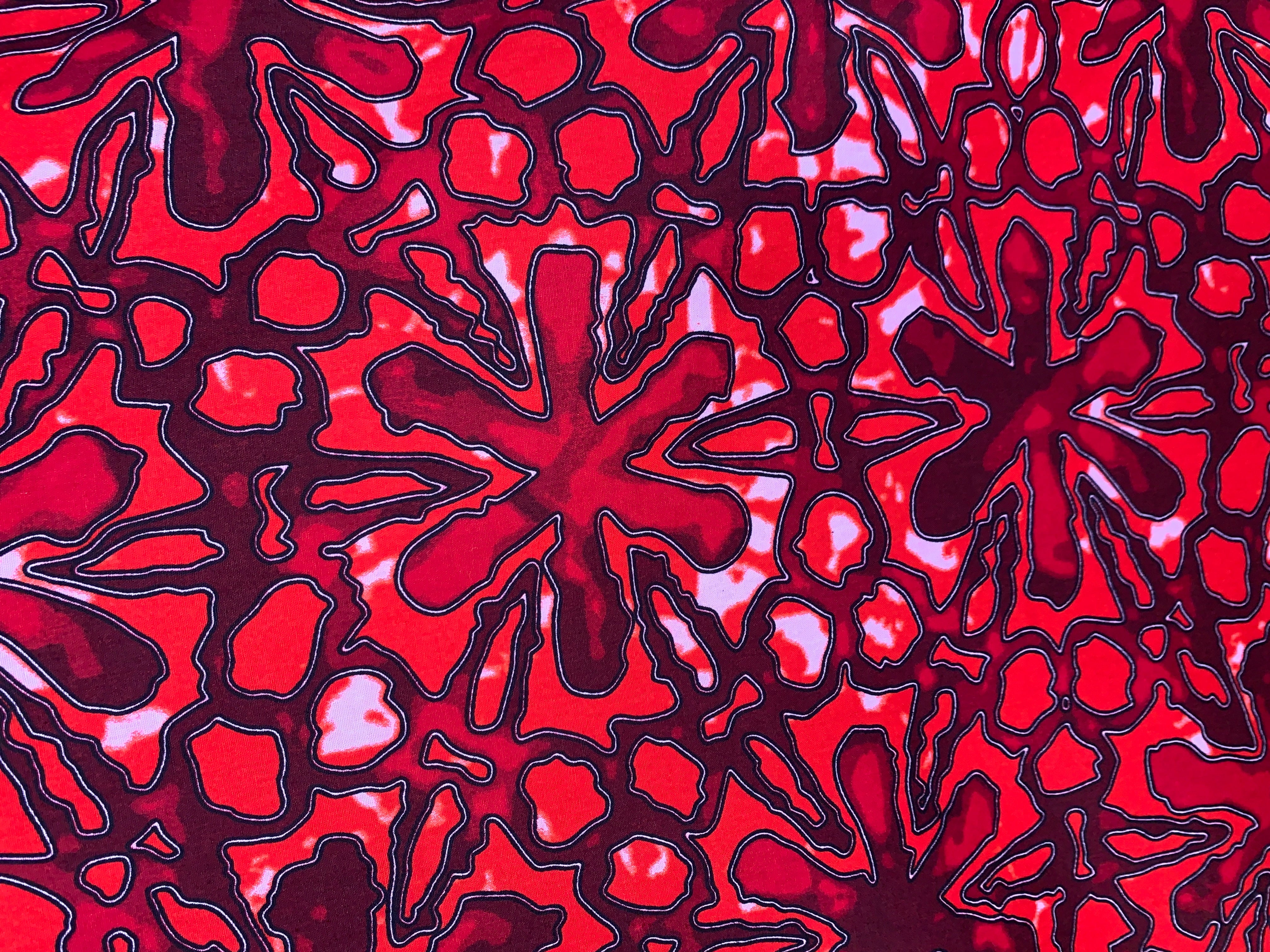 Close up display of red floral print sleeveless shirt, fabric.