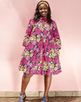 The model is wearing black, white, yellow, brown, pink, hot pink and purple bubble print dress