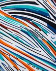 Close up display of white, black, orange, blue, aqua and brown abstract print dress