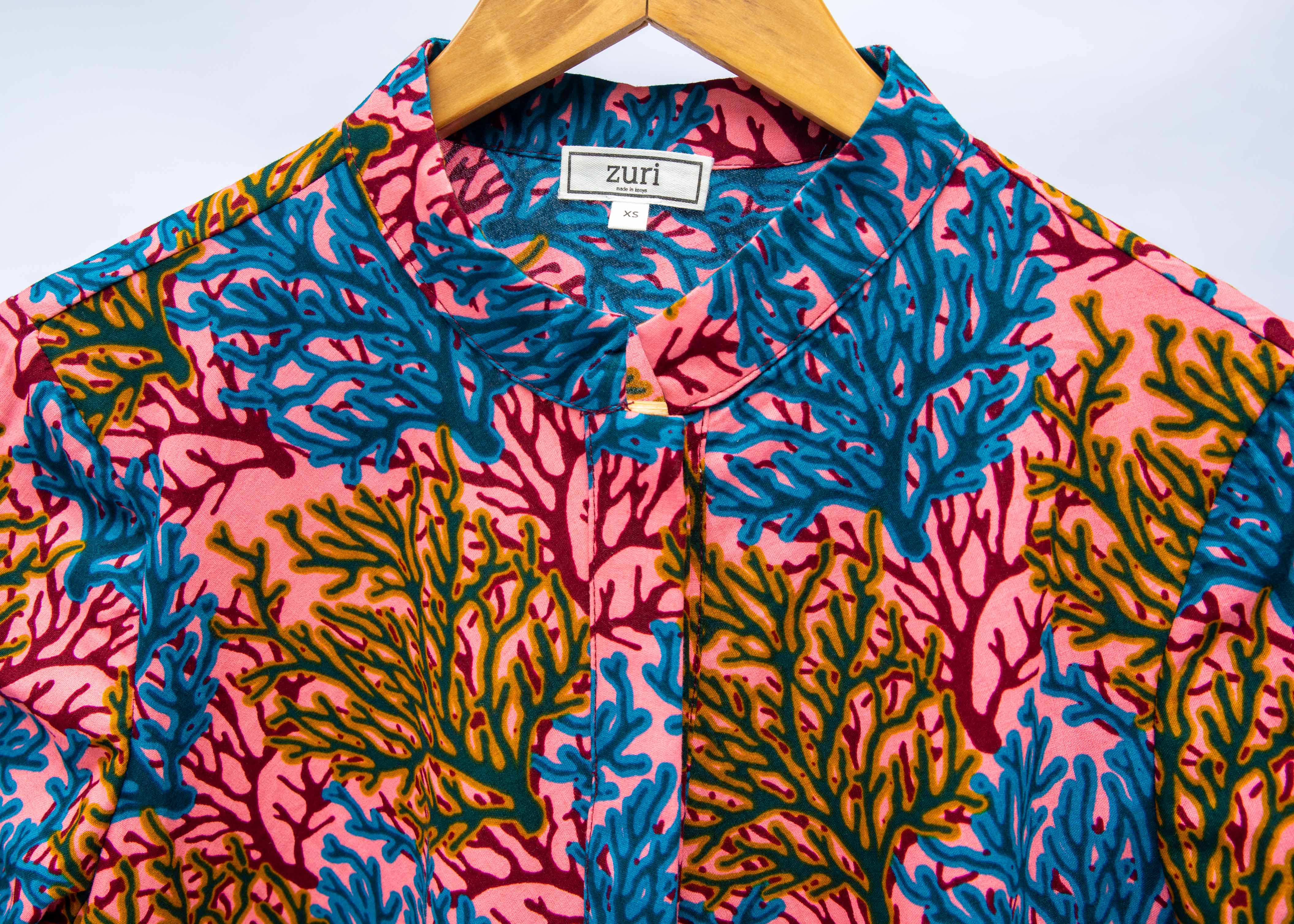 Display of a  blue, yellow and pink coral print shirt dress 