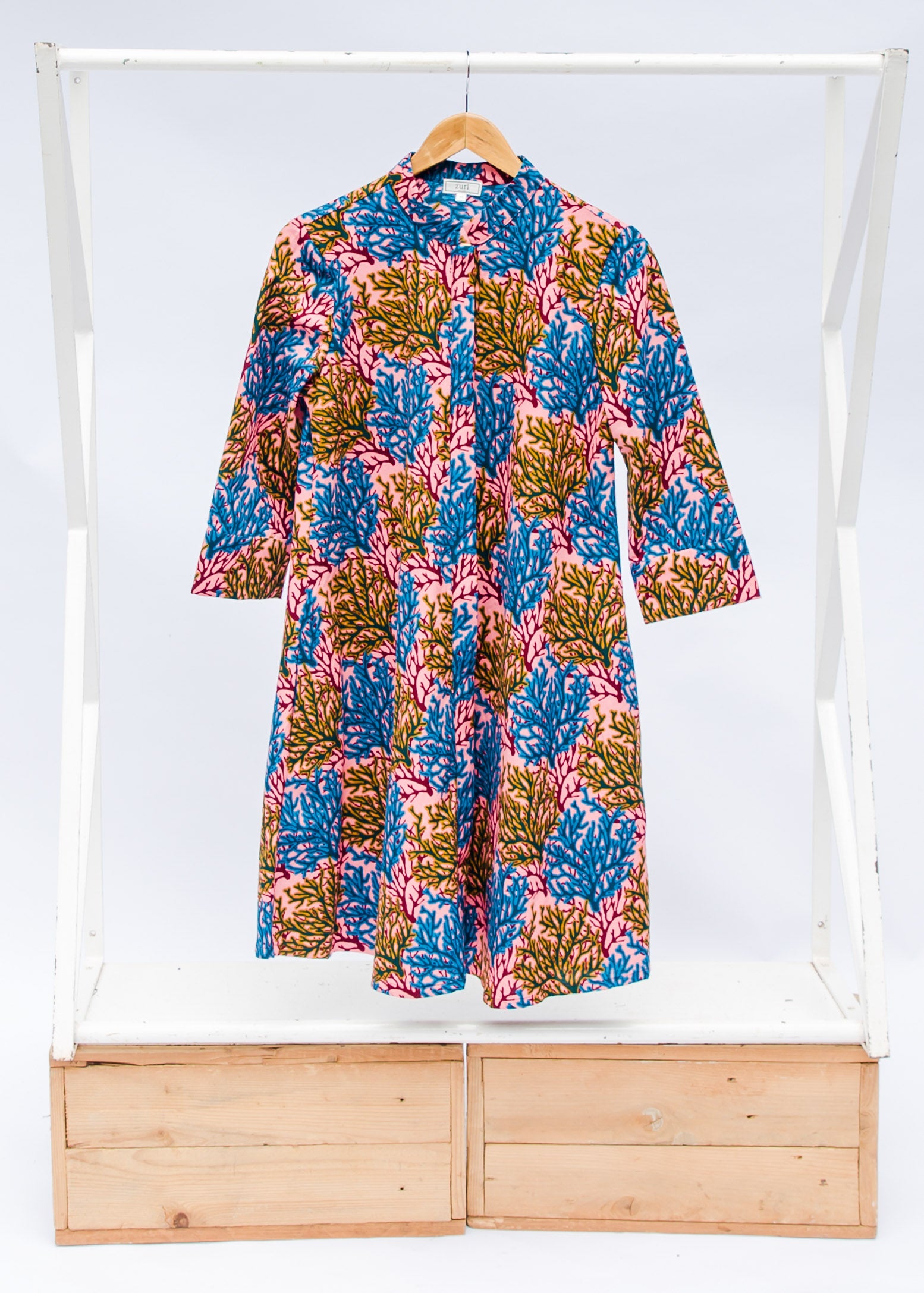 Display of a  blue, yellow and pink coral print shirt dress 