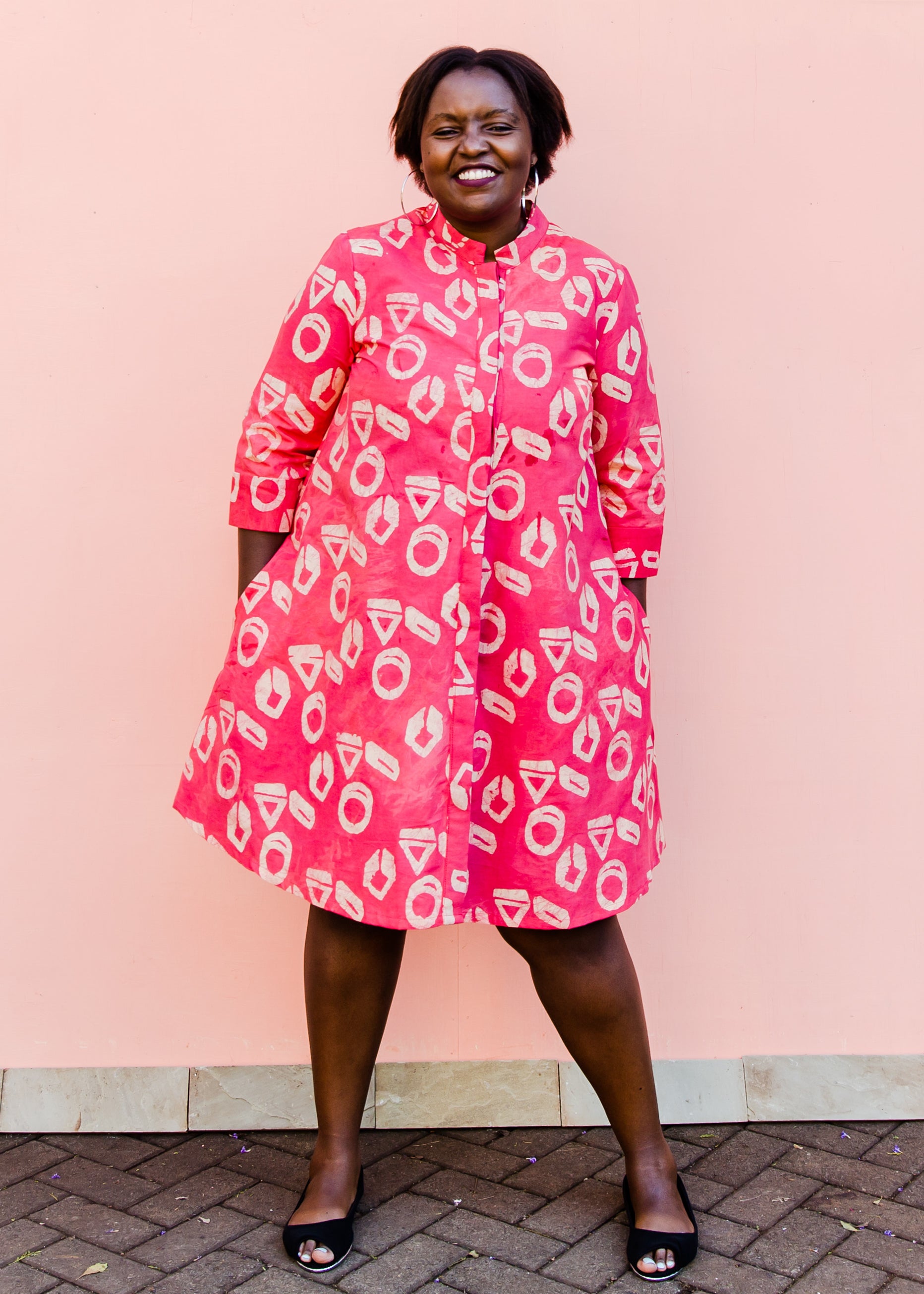 model wearing a pink and white geometric print dress