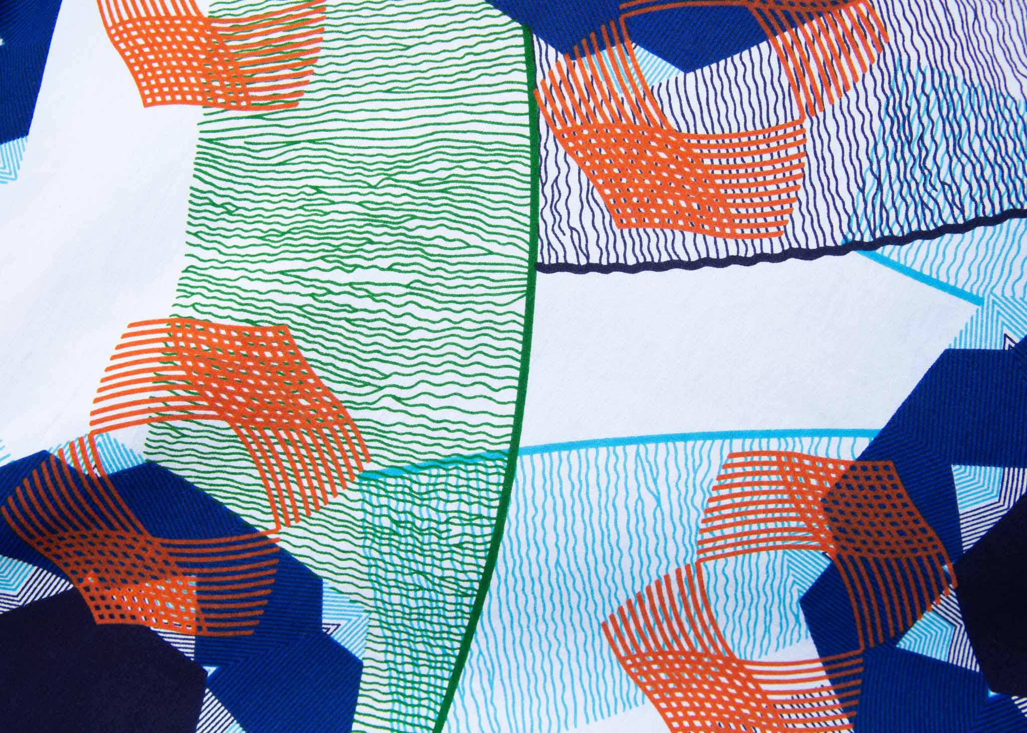 Close up display of dress with blue, green and orange abstract circular design pattern, fabric.