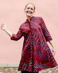 model wearing a red ladder design dress