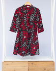 Display of red, white, and black floral print dress.