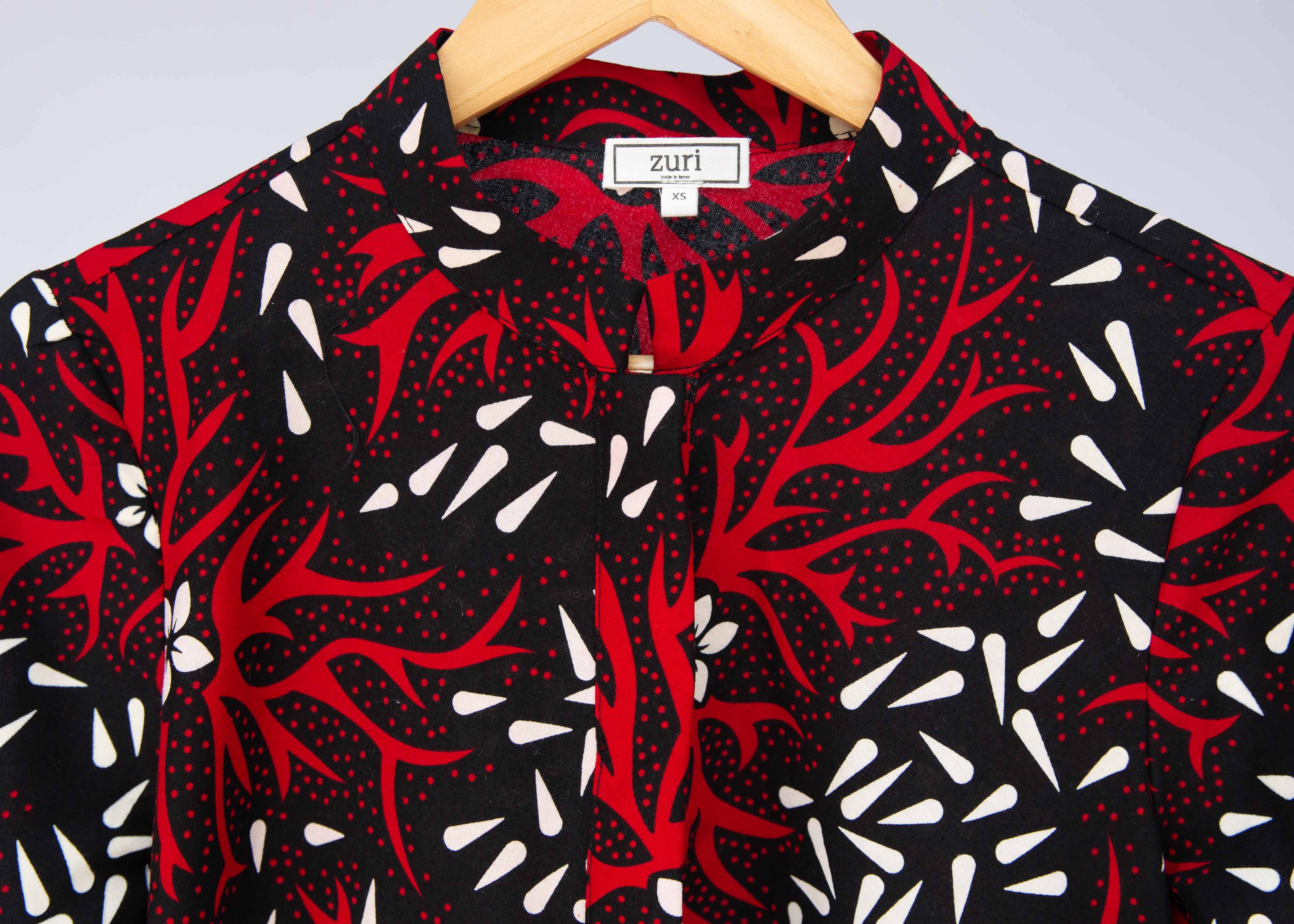 Close up display of red, white, and black floral print dress.