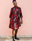 Model wearing red, white and black floral print dress, paired with black boots