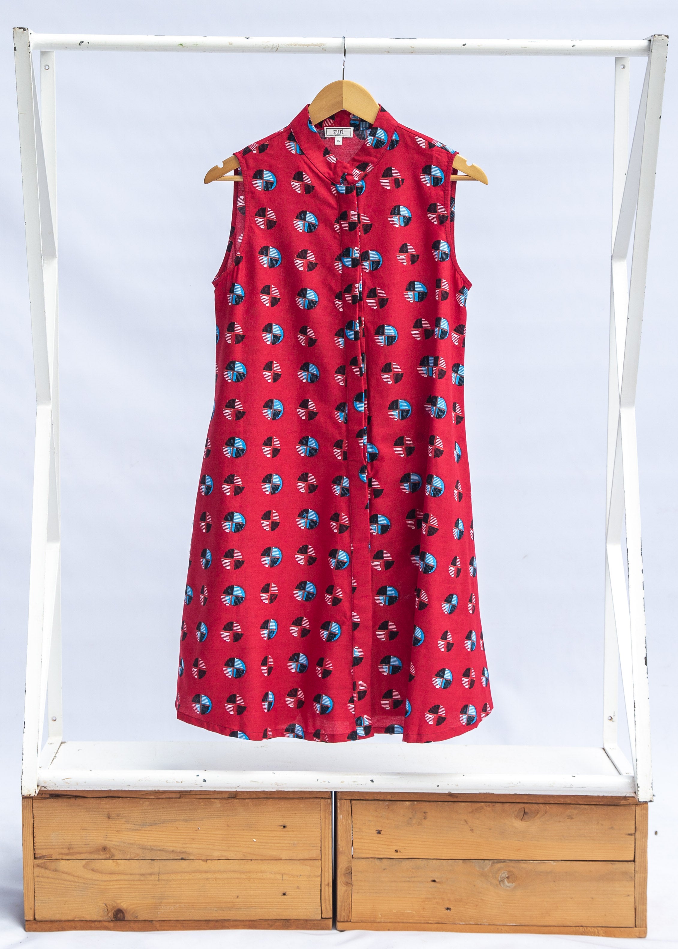 display of a sleeveless dress with a red, blue, white and black design