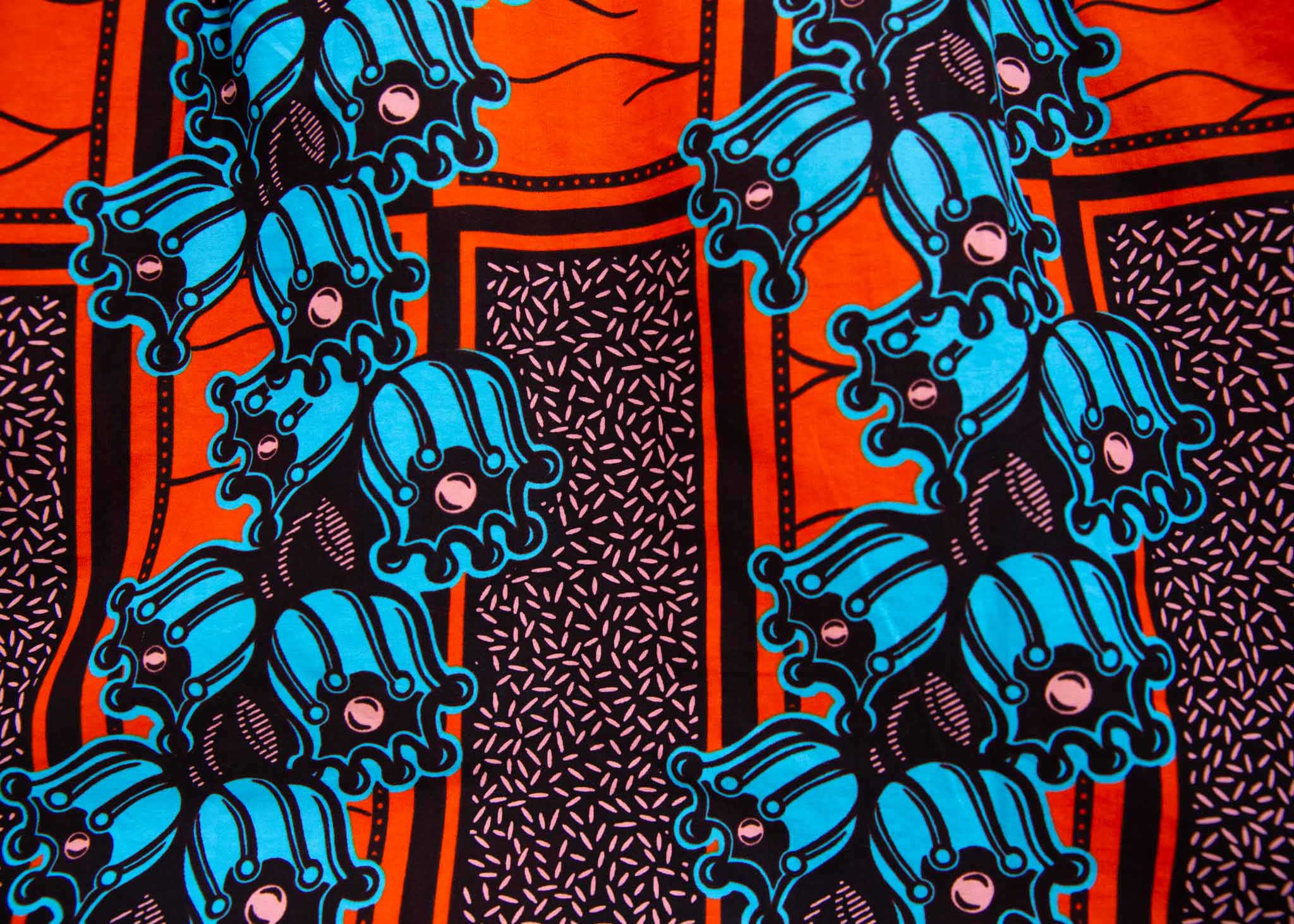 Close up display of orange and blue floral shirt, fabric.