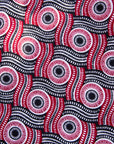 Close up display of long sleeve blouse with black, red, and white circles, fabric.