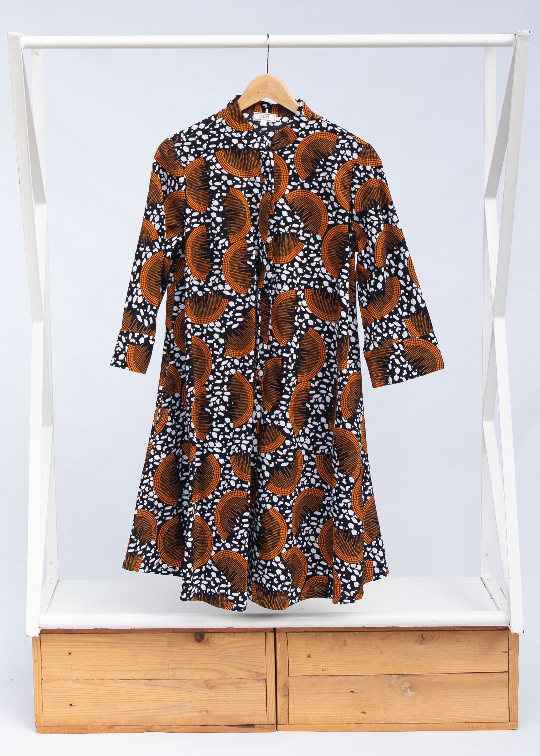 Display of black and white dress with orange half circle print.