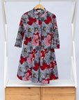 Display of dress with large grey and red flower print.