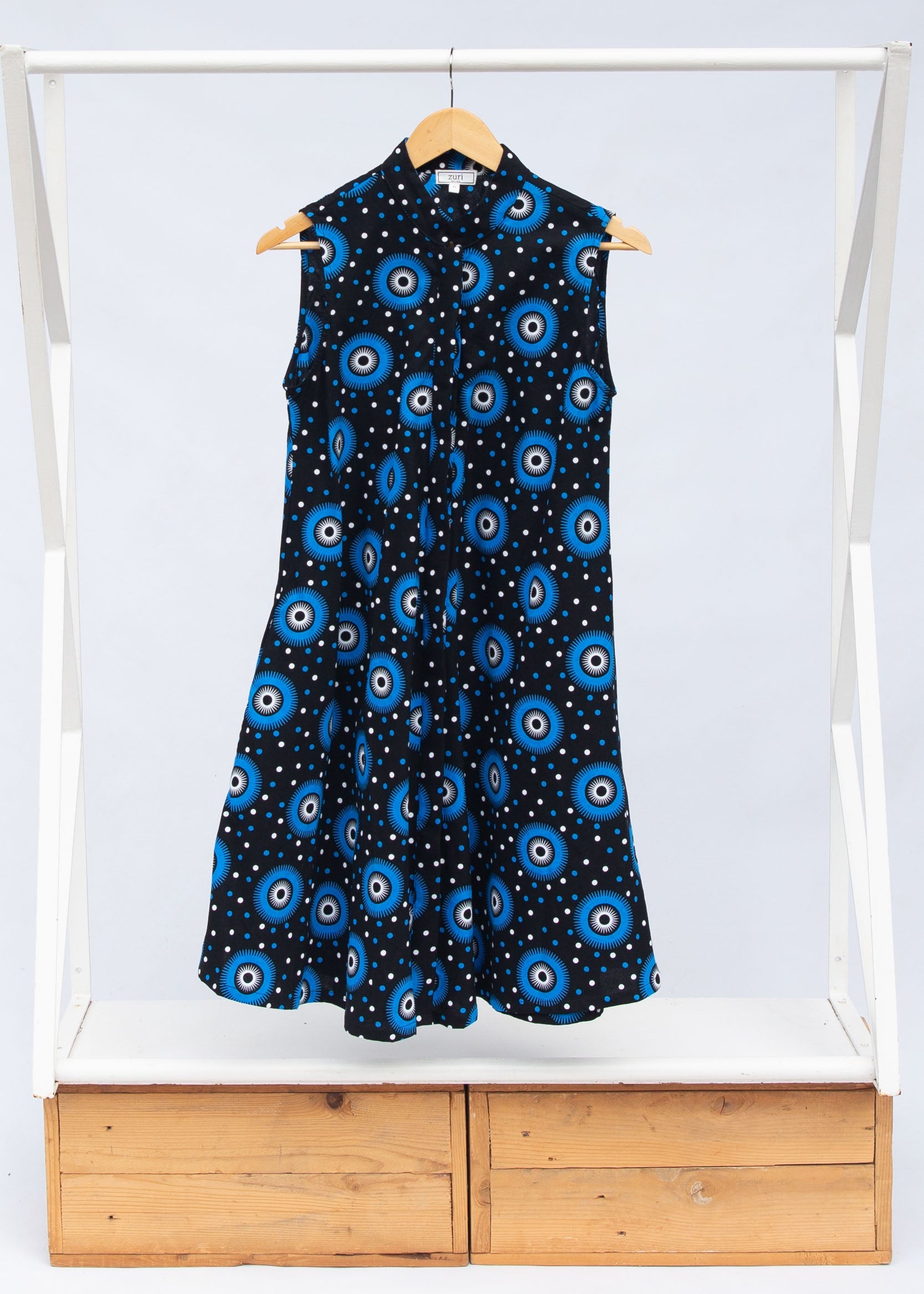 Display of black sleeveless dress with blue and white circle print.